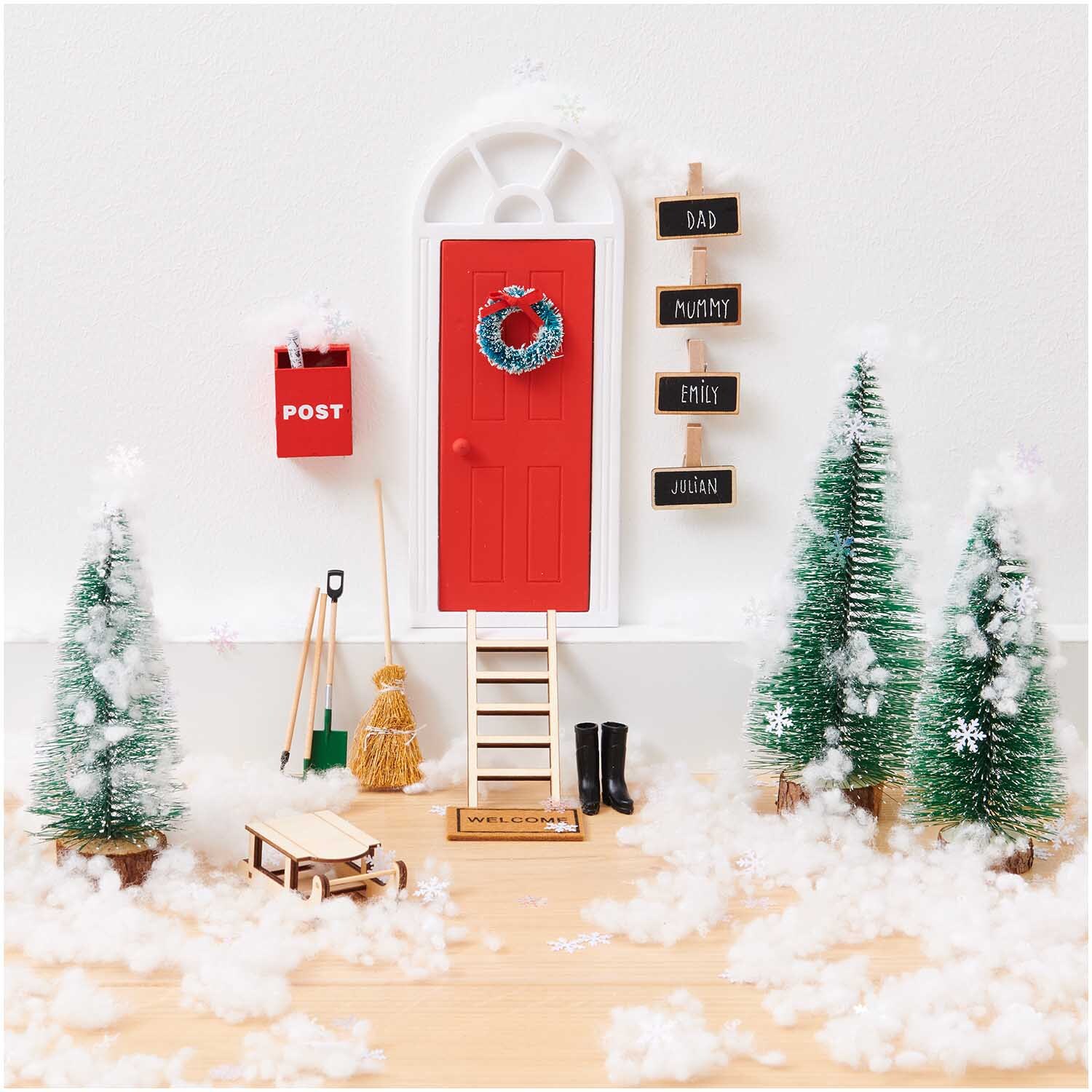 Miniatur Türkränze 5cm & 4cm von Rico Design an roter Tür, umgeben von Schneeflocken und Tannenbäumen.
