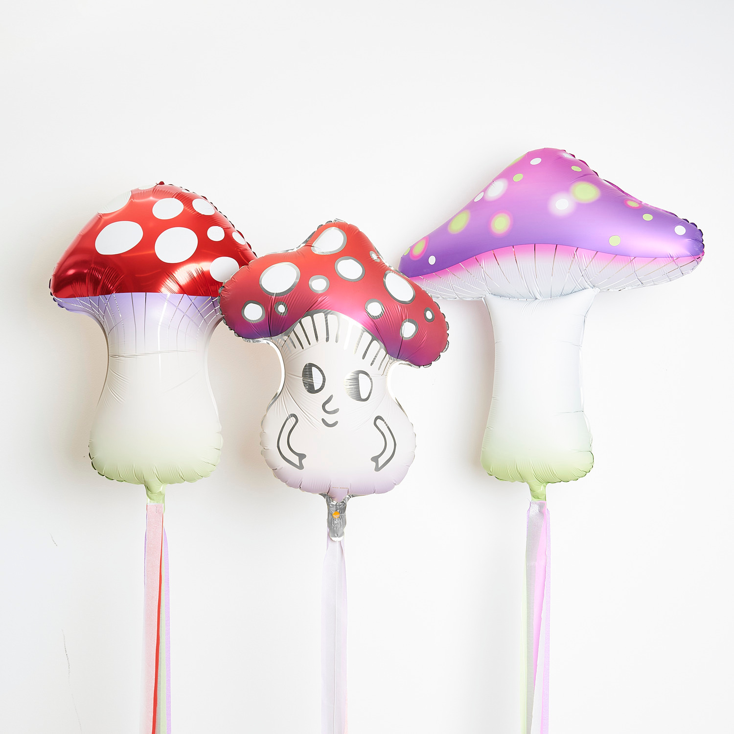 Folienballon Shrooom Rot, Lila und Funny Shrooom von Rico Design: Drei bunte Pilzballons in Rot und Lila mit lustigen Gesichtern, ideal für Partys.