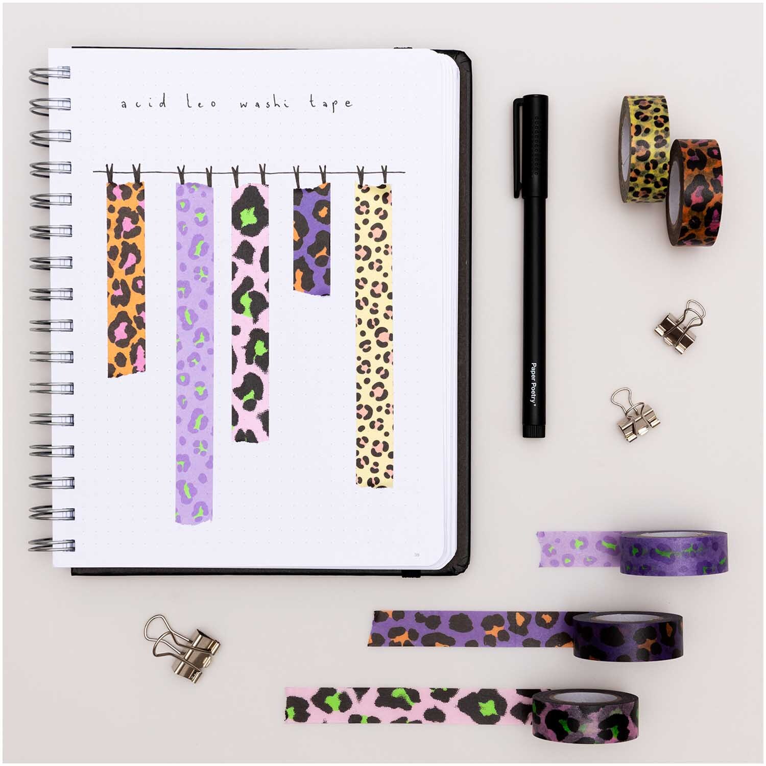Paper Poetry Tape Set Acid Leo: Fünf bunte Washi-Tapes mit Leopardenmuster von Rico Design, arrangiert neben einem Notizbuch und Stift.
