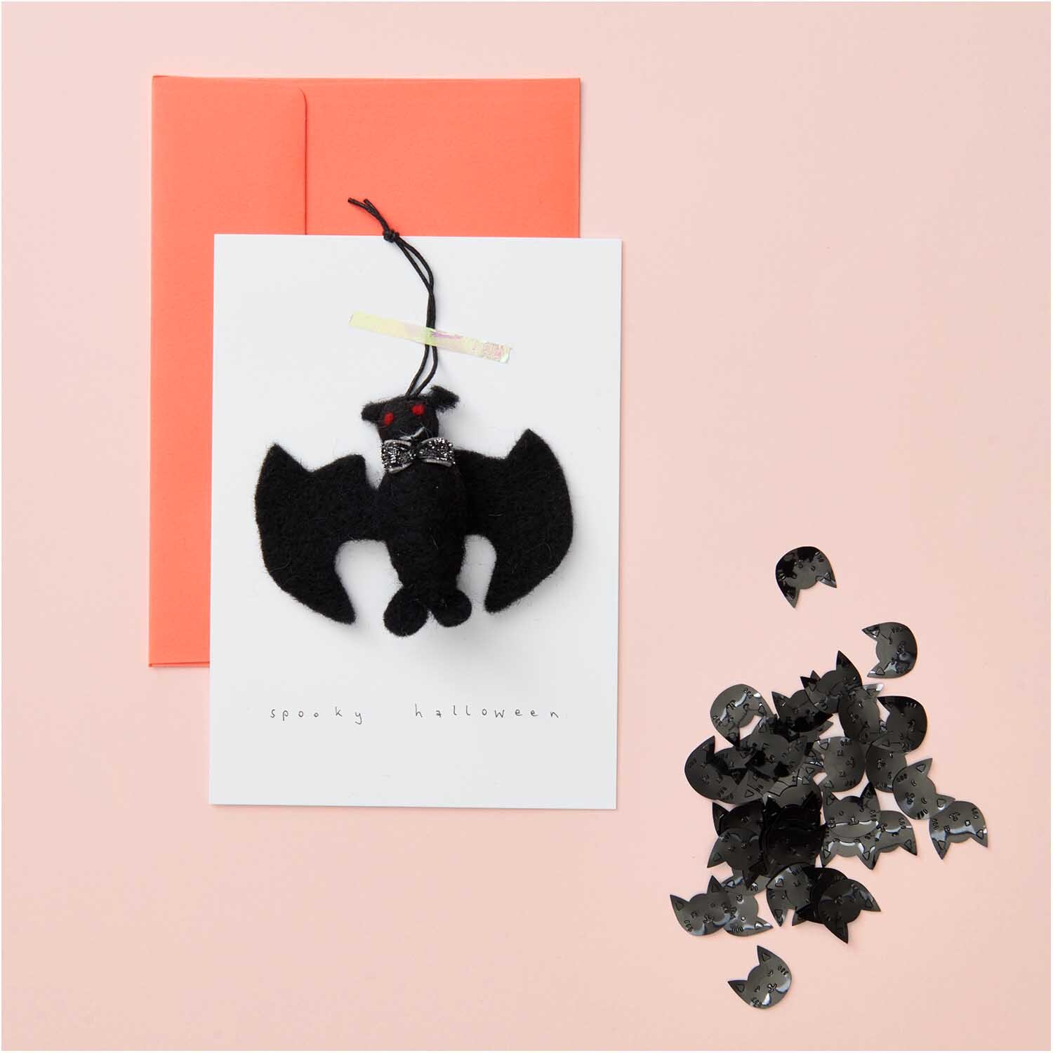Flitterstreu Katzen Mix schwarz 200 Stück auf rosa Hintergrund mit Fledermaus-Deko und Karte.