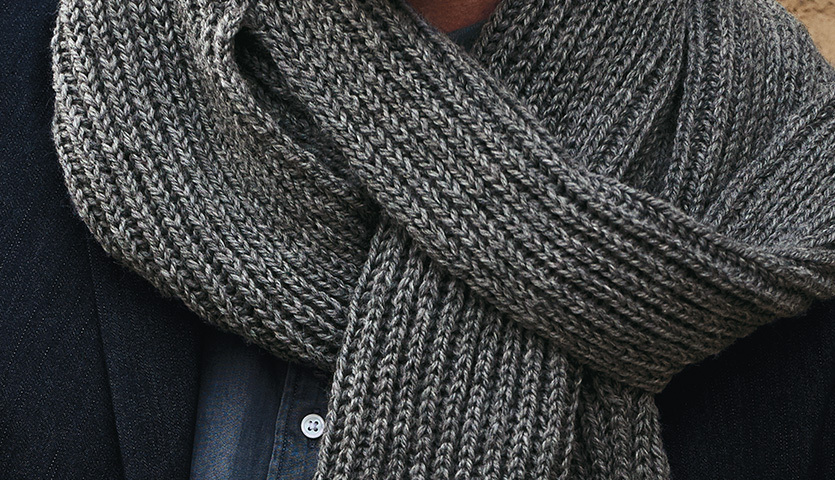 Strickanleitung Mütze und Schal aus Essentials Soft Merino aran. Grauer Schal aus weichem Merino-Garn, elegant um den Hals getragen.