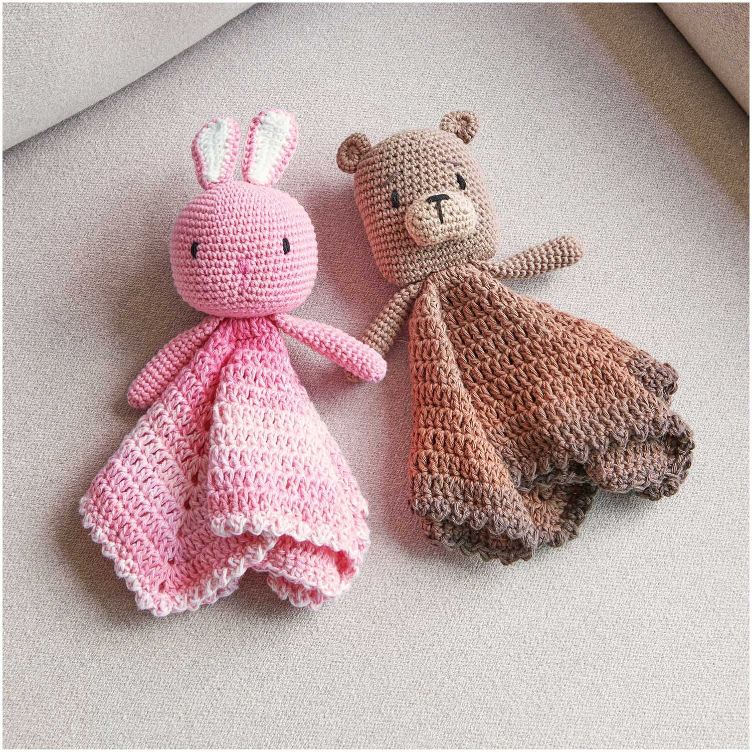 Ricorumi Spin Spin dk: Zwei gehäkelte Kuscheltiere, ein rosa Hase und ein brauner Bär, auf einem Sofa.