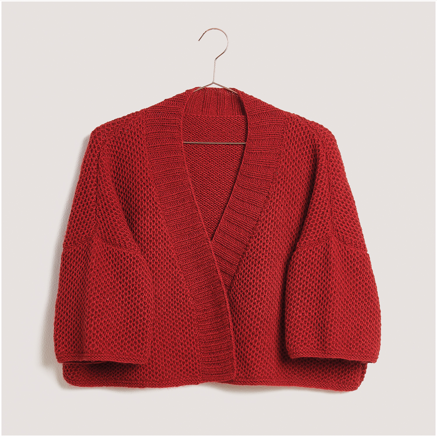 Strickset Kimono Jacke Modell 01 aus Lovewool Nr. 18, rote Jacke mit weitem Schnitt auf einem Kleiderbügel.