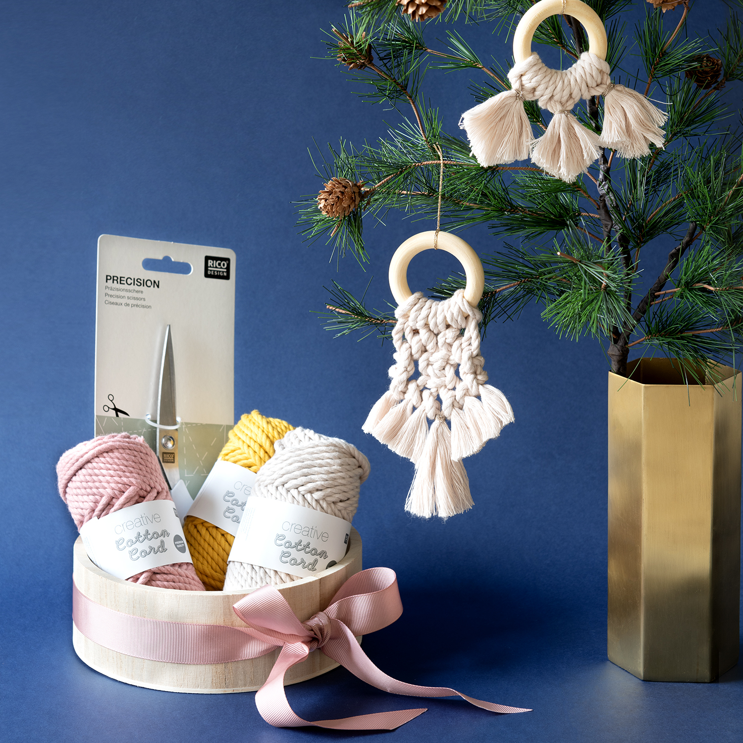 Anleitung moderne Makramee-Weihnachtsdeko: Makramee-Anhänger an einem Baum mit Garn und Schere in einem dekorativen Korb.