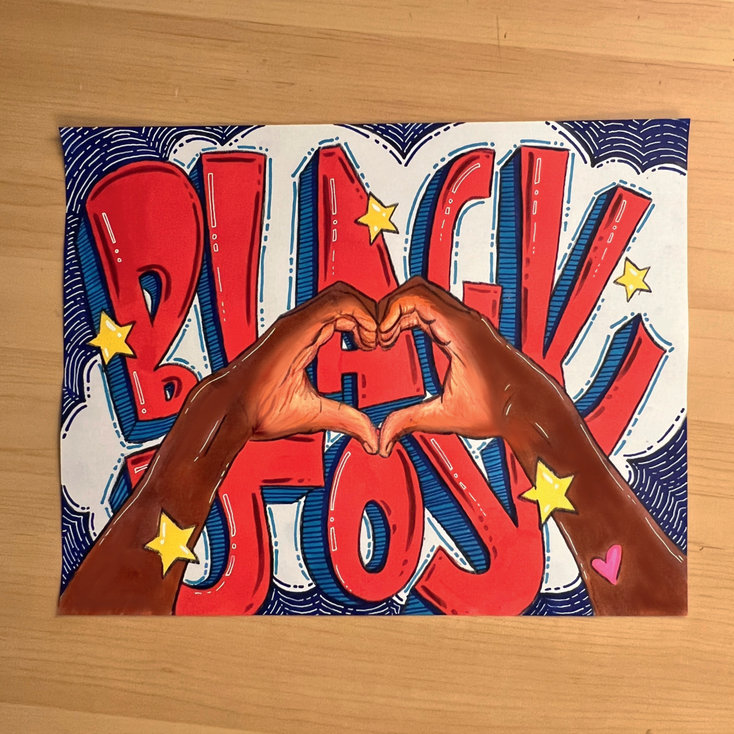 Die Welt ist bunt - Kunst gegen Rassismus: Zwei Hände formen ein Herz vor buntem Graffiti mit dem Text "Black Joy".