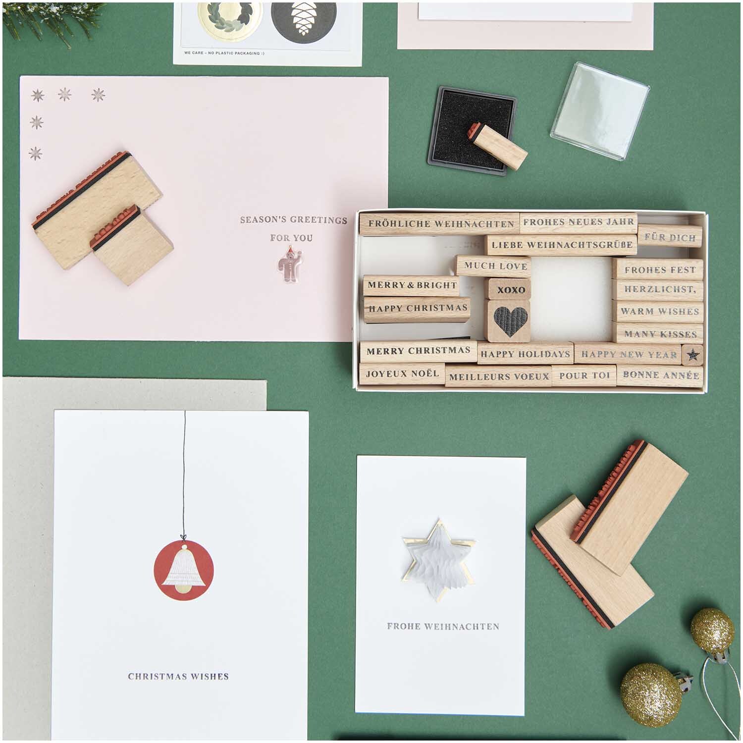 Paper Poetry XL Stempelset Merry Christmas serif, 27-teilig, auf grünem Hintergrund mit Karten.