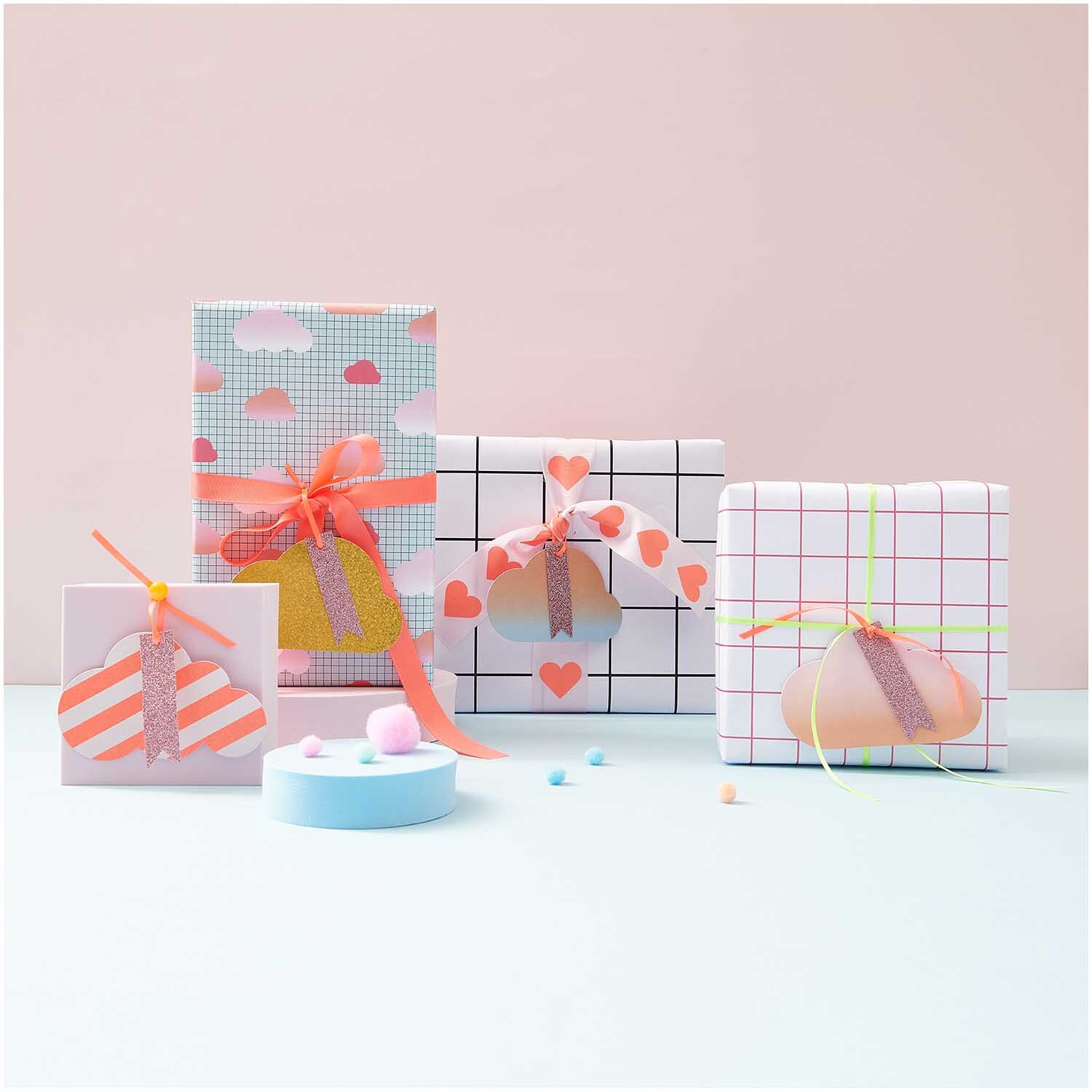 Paper Poetry Geschenkanhänger Wolken 4 Stück von Rico Design, dekoriert auf bunten Geschenken mit Herz- und Wolkenmotiven.