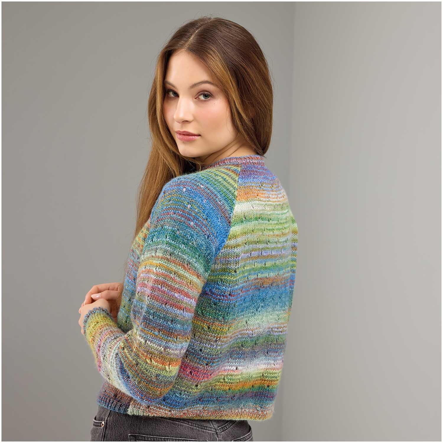 Strickset Jacke Modell 26: Frau trägt bunte, gestreifte Strickjacke, die modern und stilvoll wirkt. Ideal für kühle Tage.