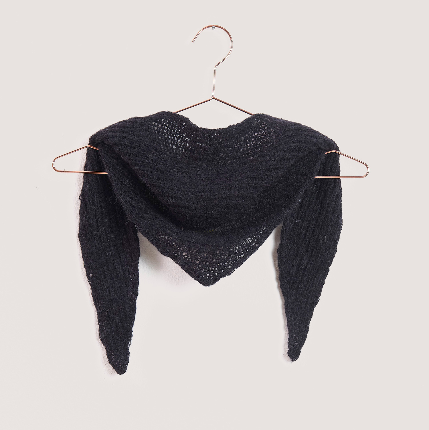 Strickset Mini Dreieckstuch Modell 08c, elegant in Schwarz, präsentiert auf einem Kleiderbügel. Ideal für stilvolle Handarbeitsprojekte.