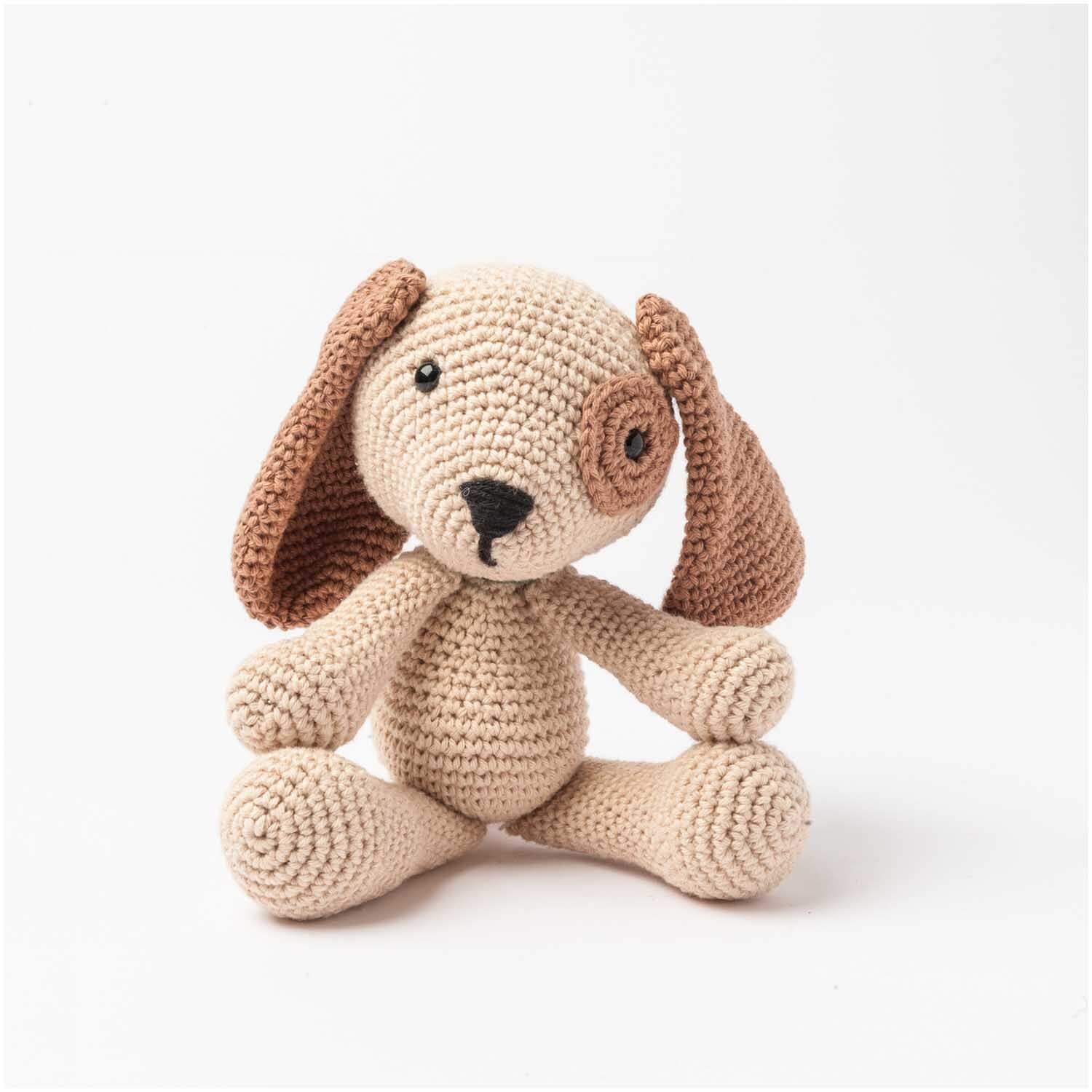 Häkelset Ricorumi Puppies Hund: Ein beige-brauner, gehäkelter Welpe von Rico Design mit langen Ohren.