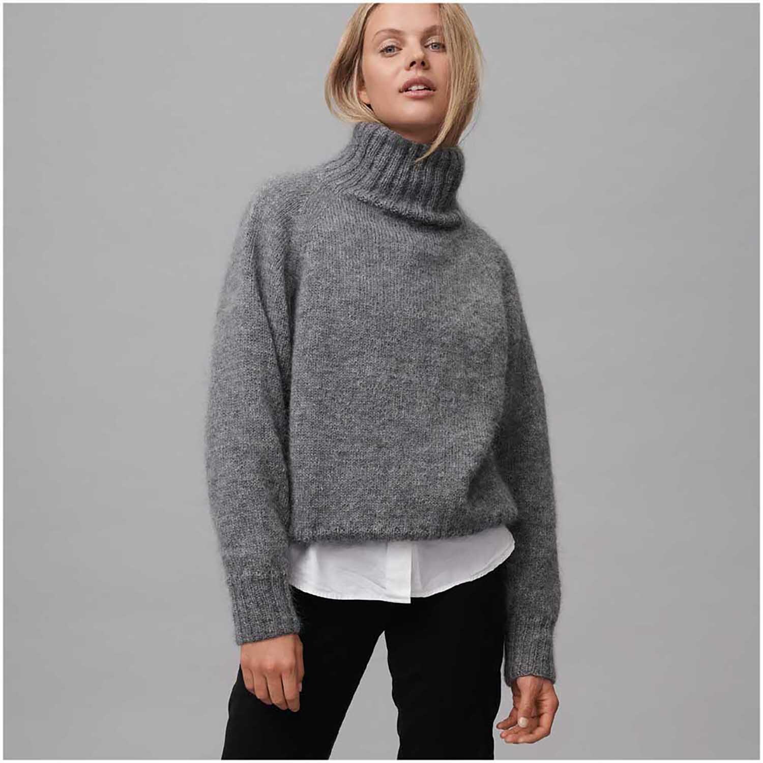 Strickset Pullover Modell 04: Grauer Rollkragenpullover aus weichem Material, kombiniert mit weißem Hemd und schwarzer Hose.