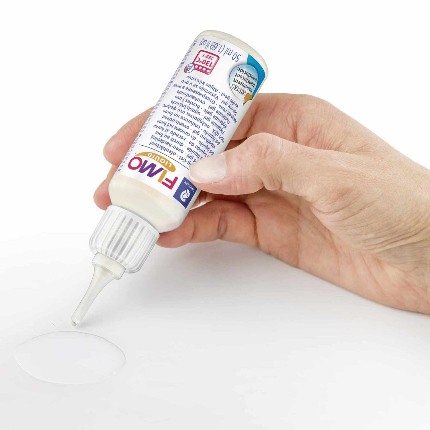 FIMO Liquid ofenhärtendes Modelliergel wird aus einer Flasche auf eine Oberfläche gegossen.