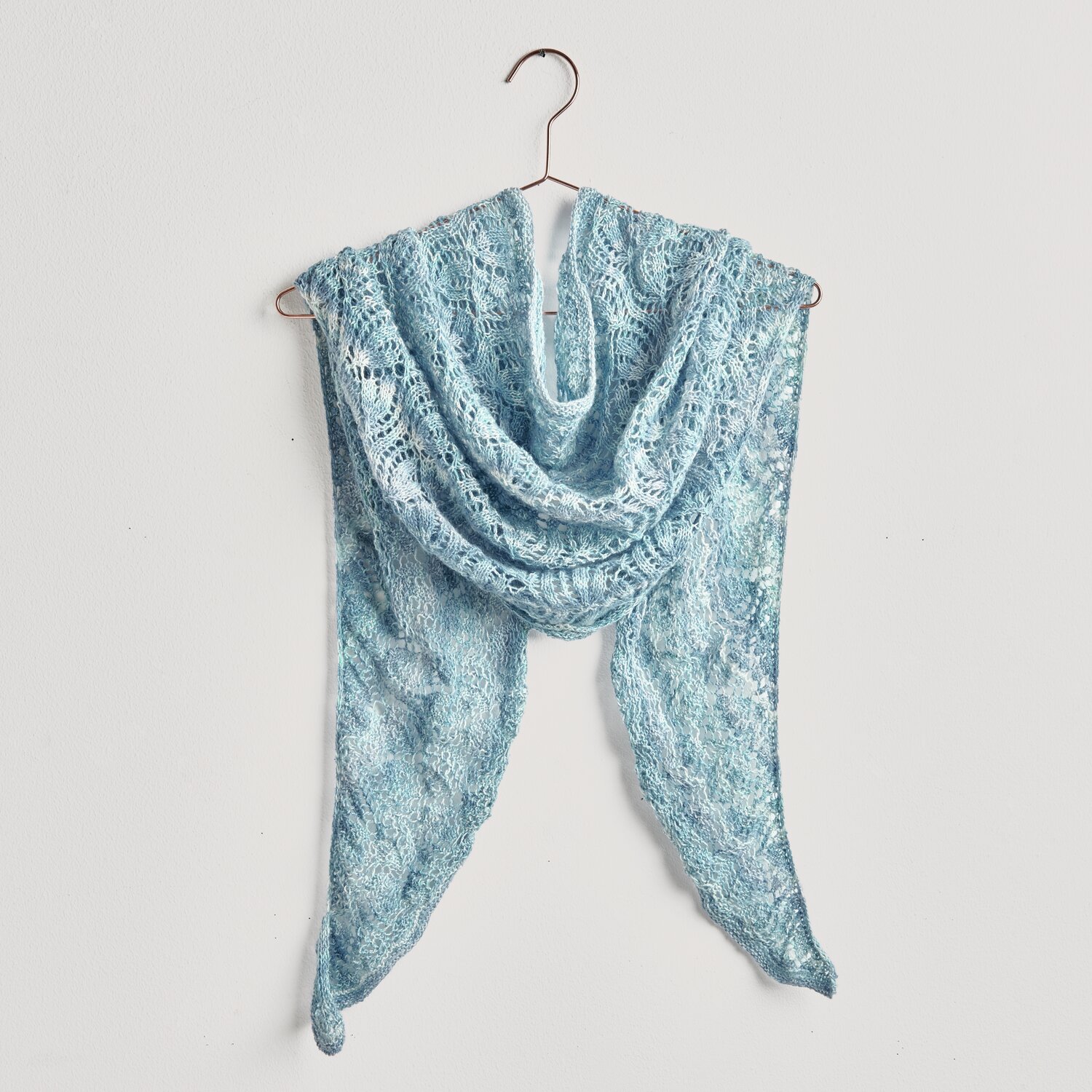 Strickset Dreieckstuch Modell 08: Hellblaues Tuch aus Fashion Cotton Merino Lace, elegant drapiert auf einem Kleiderbügel.