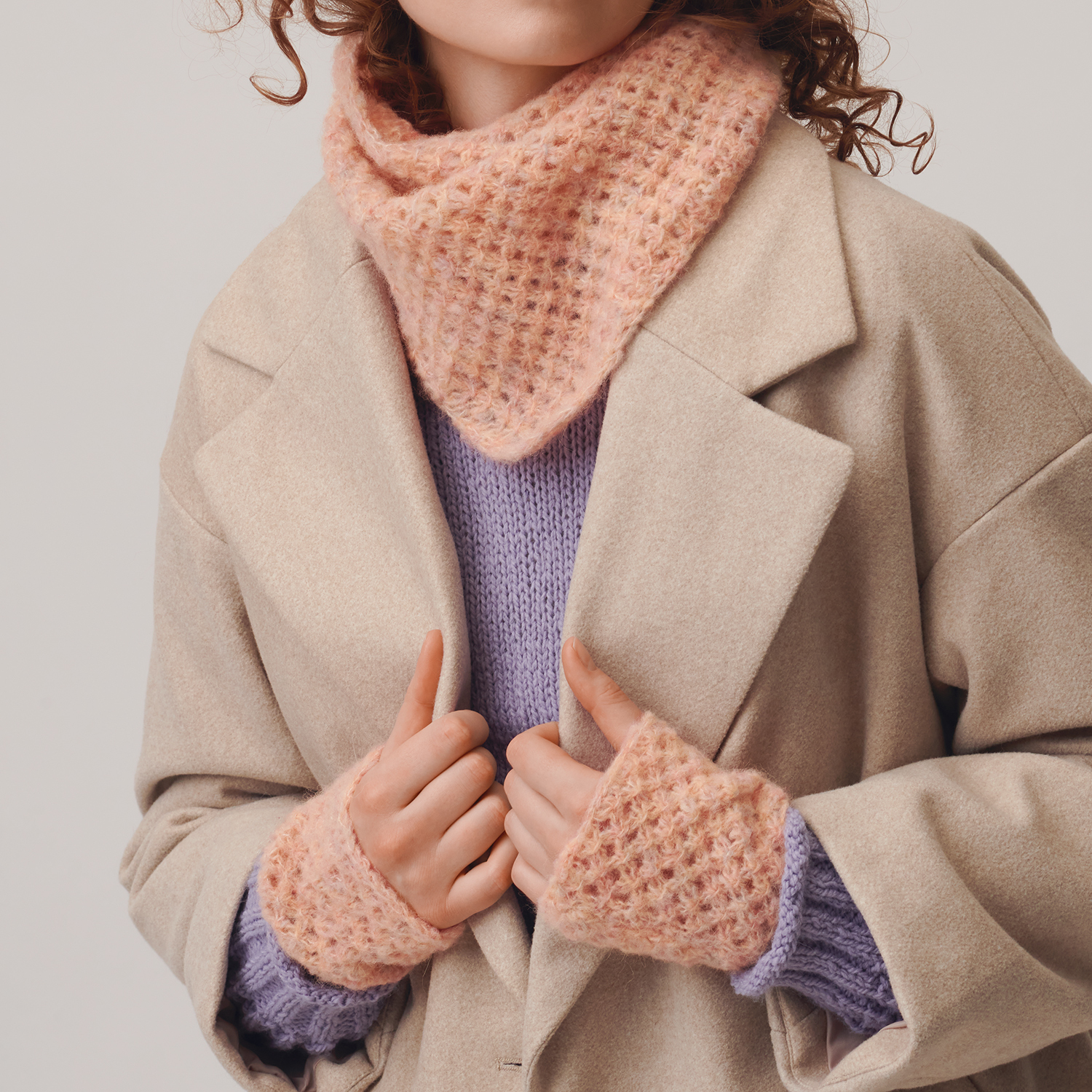 Strickanleitung Dreieckstuch und Stulpen aus Fashion Skinny Alpaca aran: Frau trägt ein gestricktes, rosafarbenes Dreieckstuch und passende Stulpen.