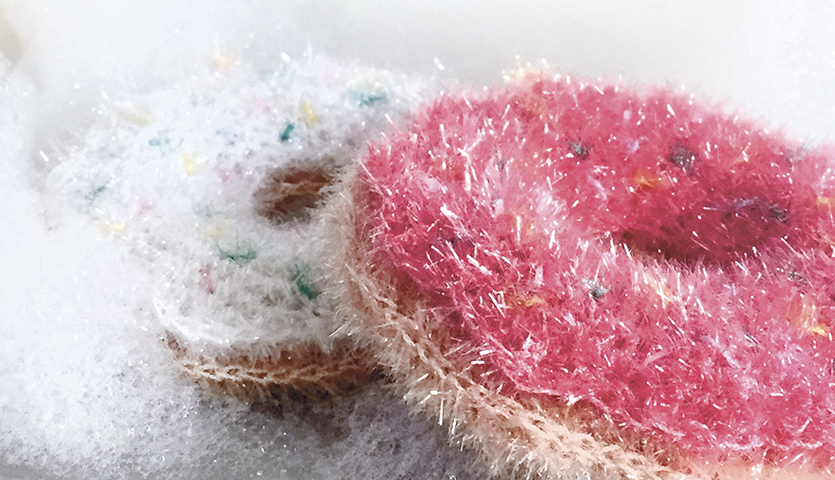 Häkelanleitung Donut Spülschwamm aus Creative Bubble: Zwei bunte, flauschige Donut-Spülschwämme in Schaum.