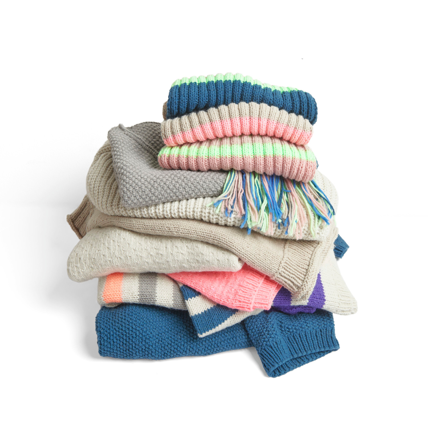 Essentials Vegan Cashmere aran: Ein Stapel gestrickter Pullover in verschiedenen Farben, ideal für gemütliche Wintertage.
