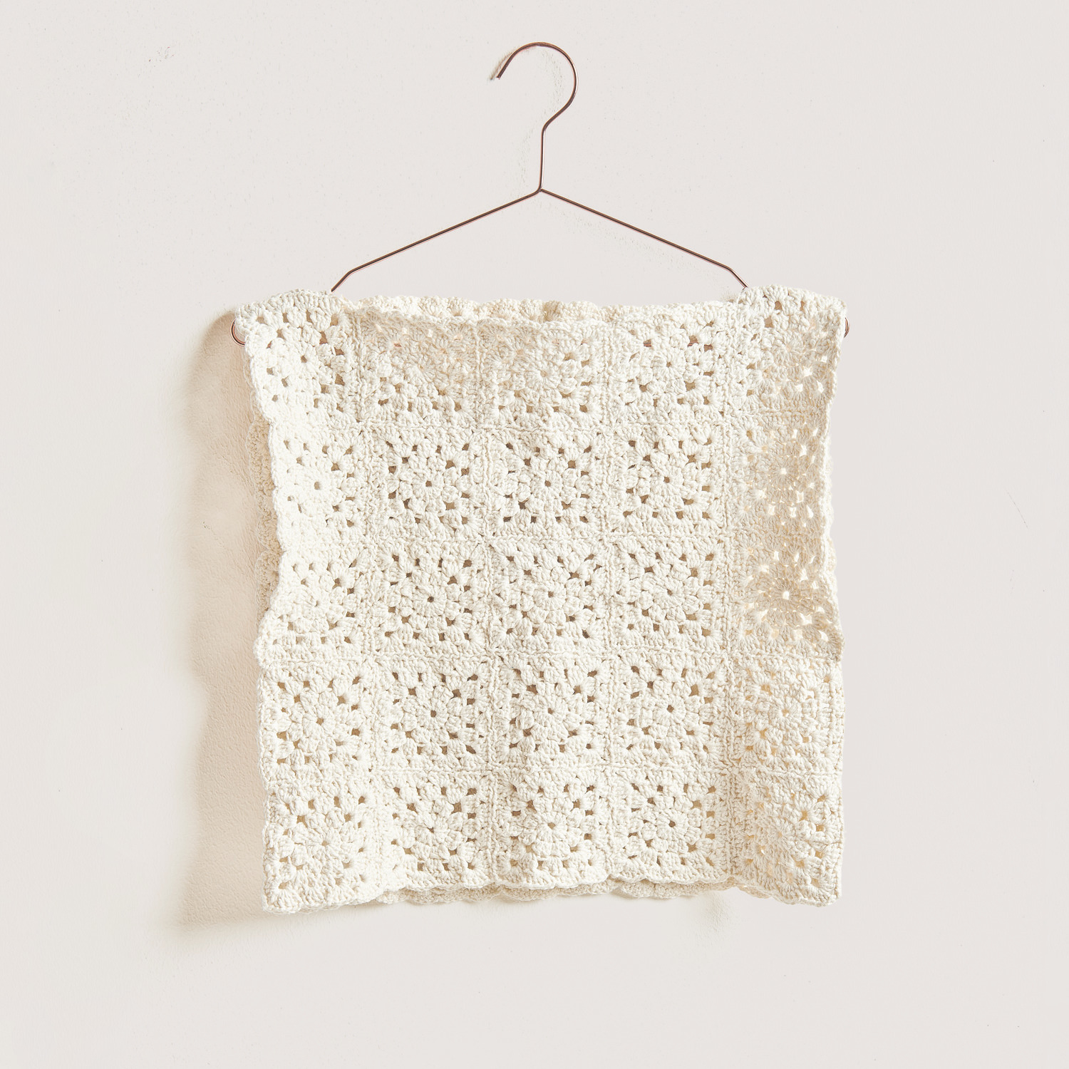 Granny Square Pullunder auf grauem Hintergrund – zum Häkelset