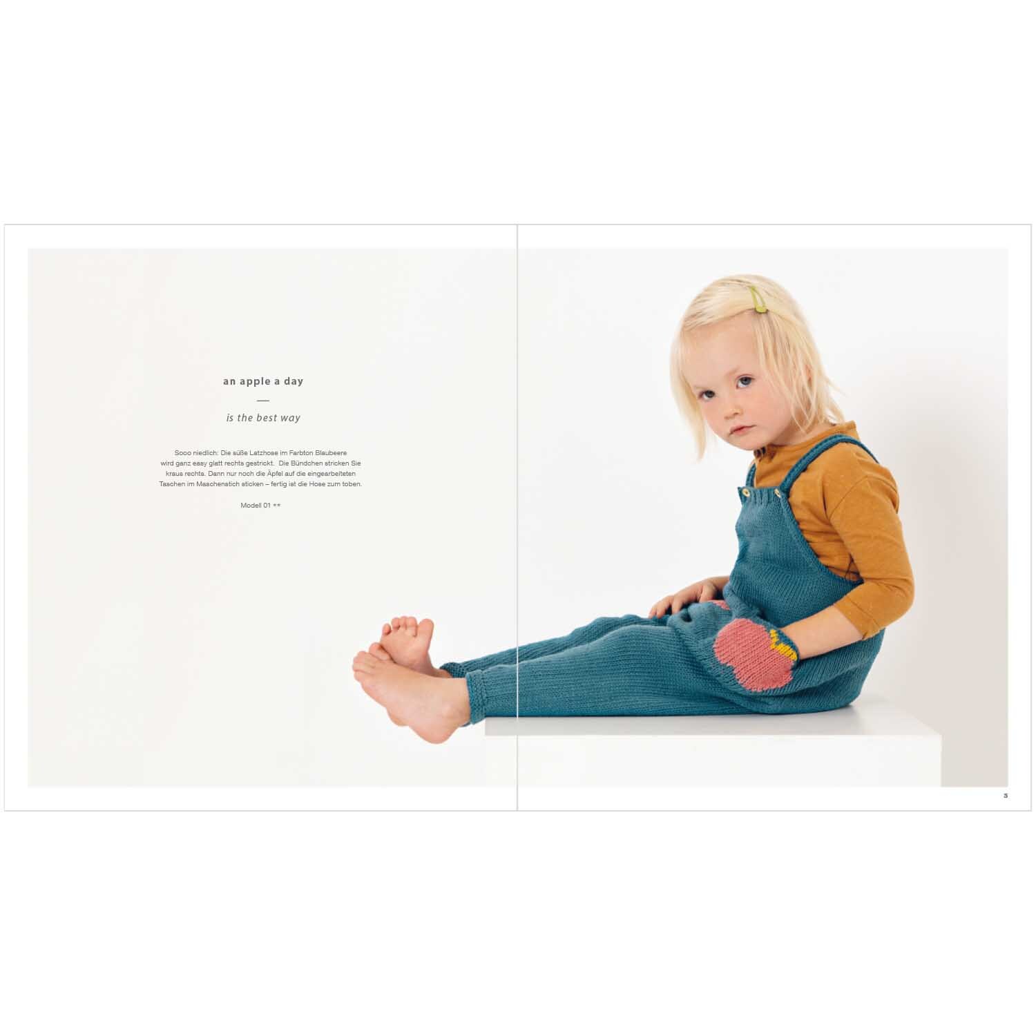 Rico Baby Heft Nr.27 zeigt ein Kind in blauer Latzhose und gelbem Oberteil, sitzend auf weißem Hintergrund.