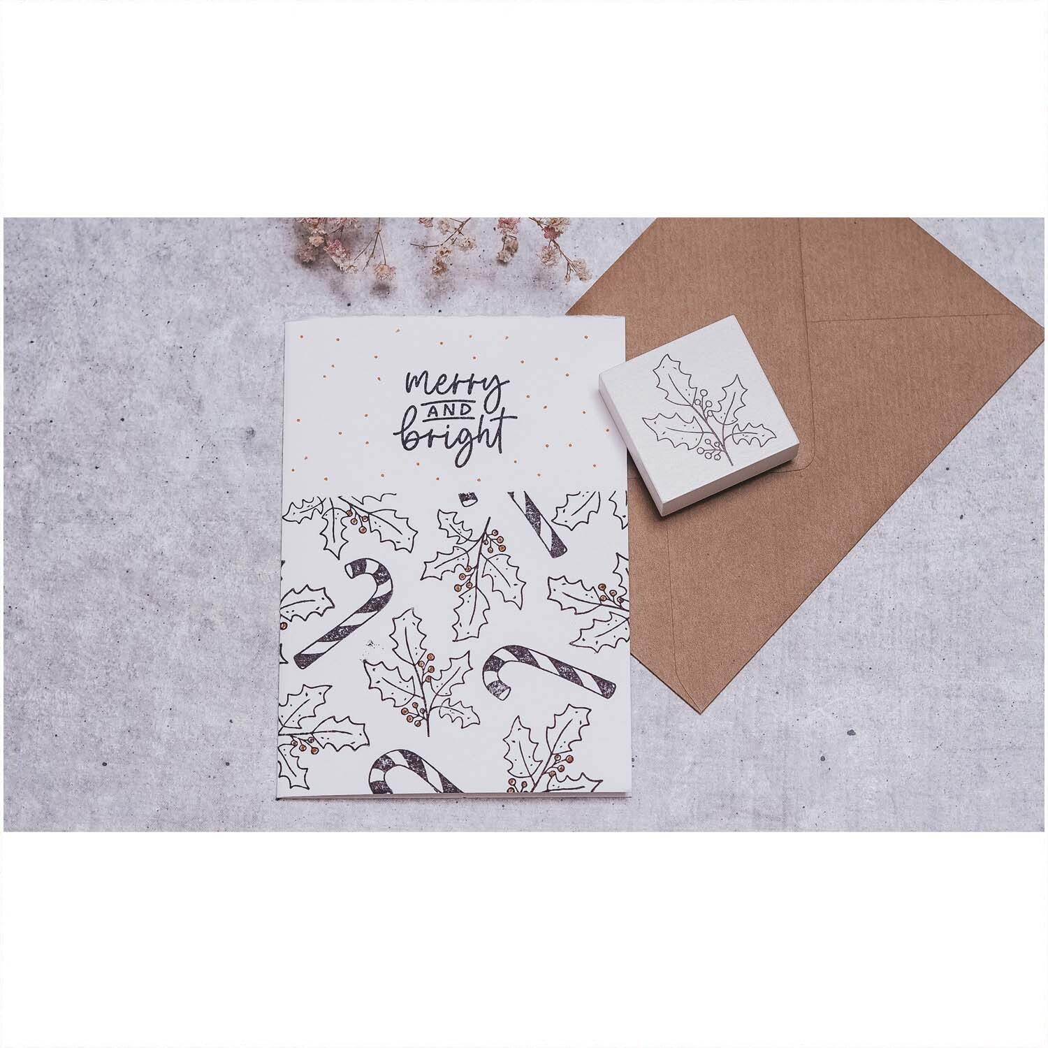 Stempel Ilexzweig weiß 45x45mm von May&Berry auf einer Karte mit Ilex- und Zuckerstangenmotiv.