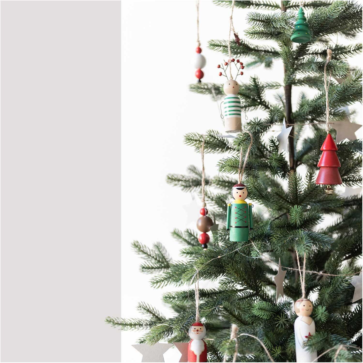 Holzhänger Rentier aus Holzkugeln an einem Weihnachtsbaum mit weiteren bunten Dekorationen.