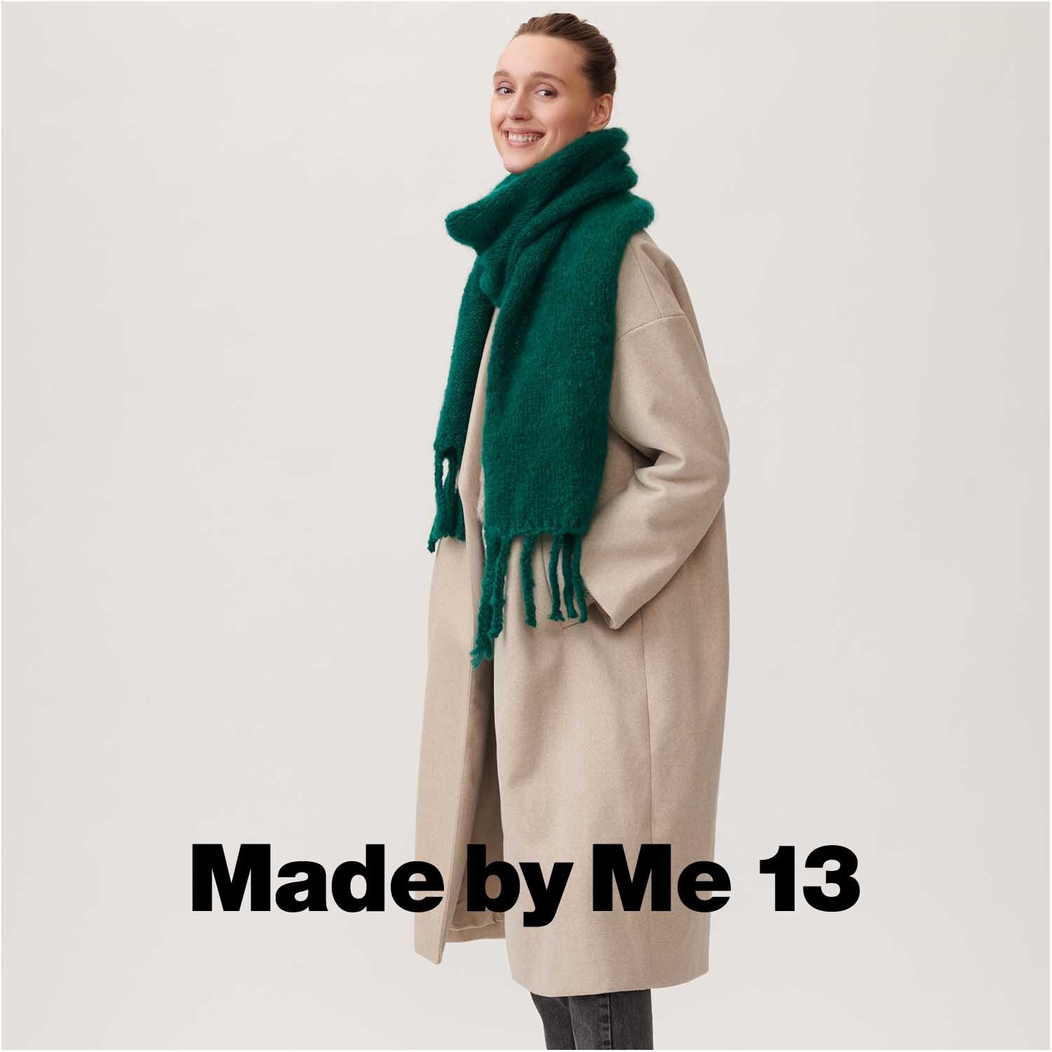 Fashion Mohair Merino Chunky Schal in Alge von Rico Design, getragen von einer lächelnden Person in beigem Mantel.