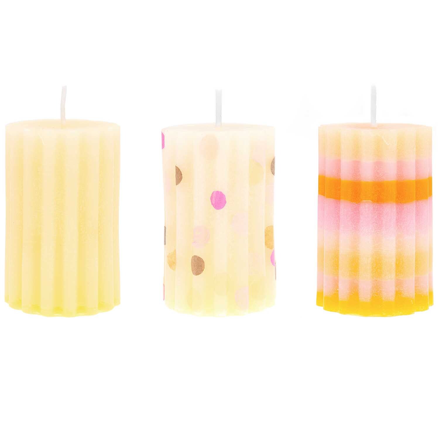 Kerzengießform Zylinder geriffelt von Rico Design, zeigt drei bunte, geriffelte Kerzen.