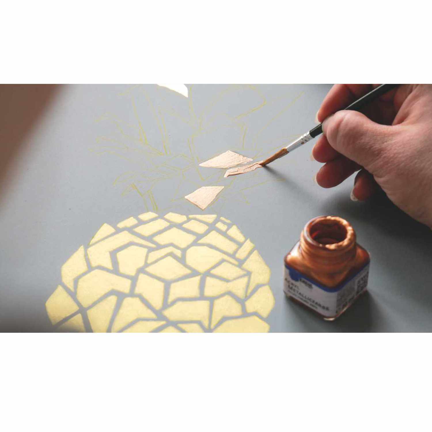 Acryl Metallicfarben Set Glamour Living: Hand malt mit Pinsel goldene Muster auf grauer Oberfläche.