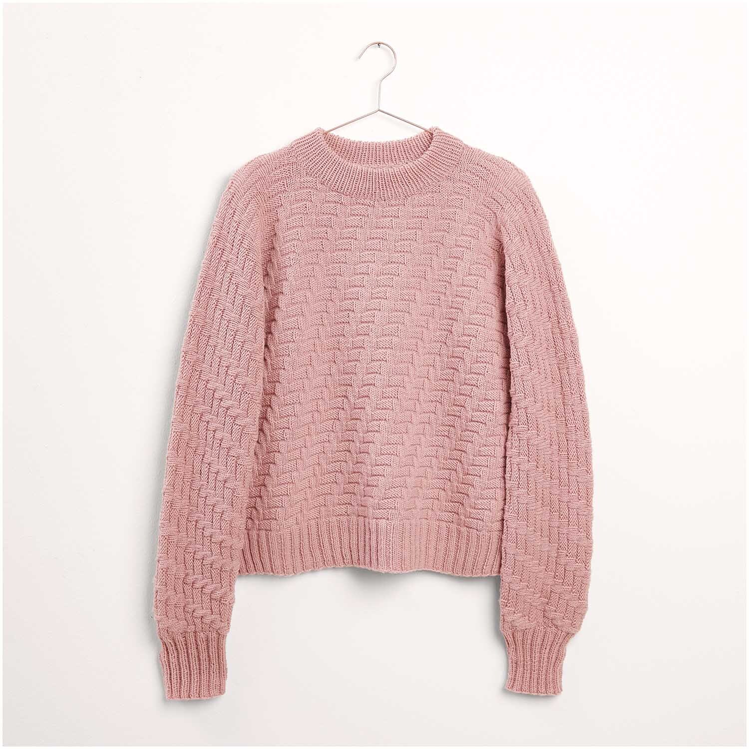 Strickset Pullover Modell 09 aus Die Neue Masche Nr. 7: Rosa Pullover mit Zopfmuster, hängend an einem Kleiderbügel vor weißem Hintergrund.