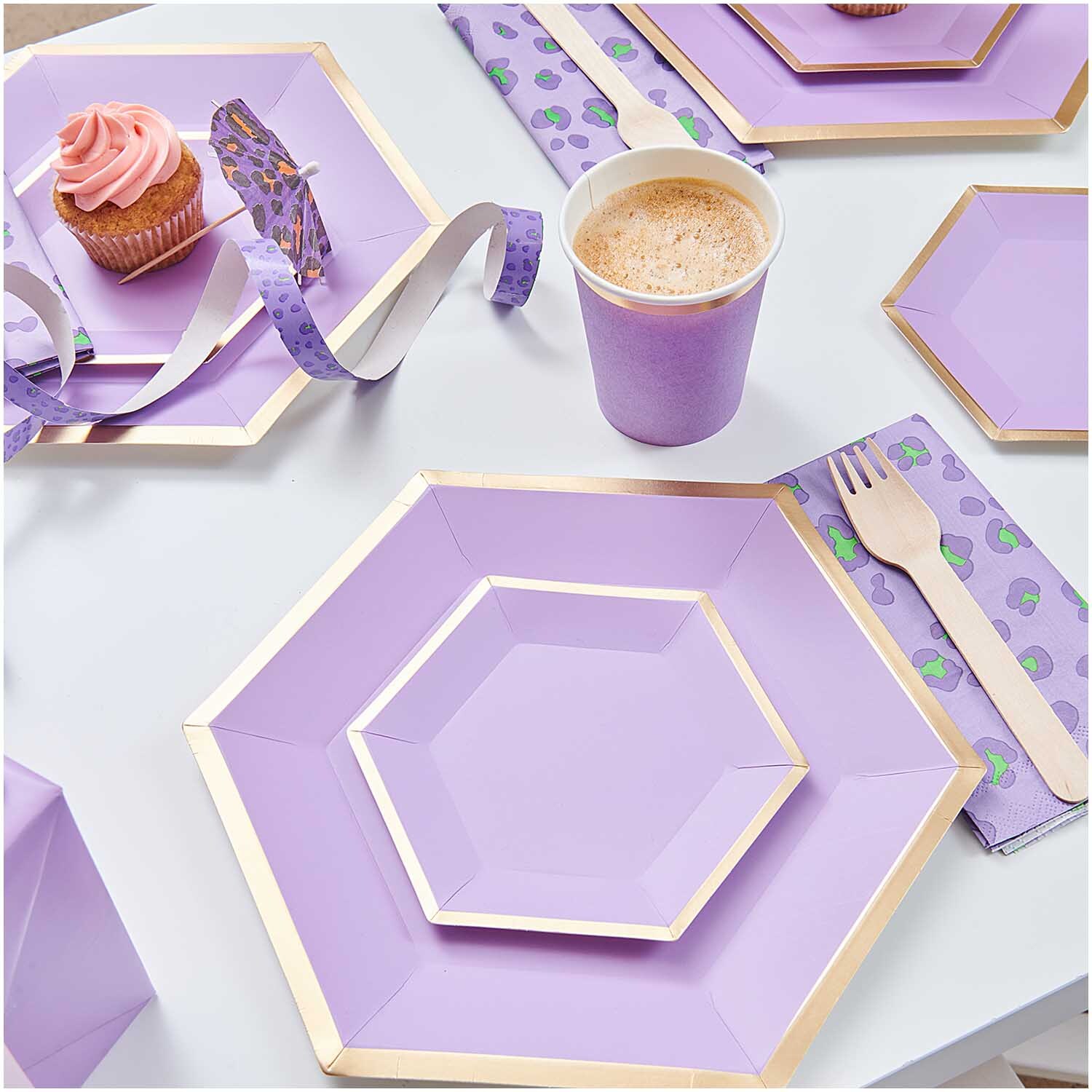 Pappteller Sechseck flieder-gold von Rico Design, dekoriert mit Cupcake und Kaffee auf Tisch.
