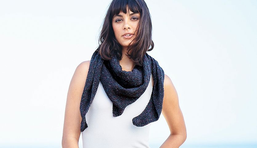 Strickanleitung Dreieckstuch aus Fashion Cottony: Frau trägt ein elegantes, dunkles Dreieckstuch. Ideal für stilvolle Outfits.