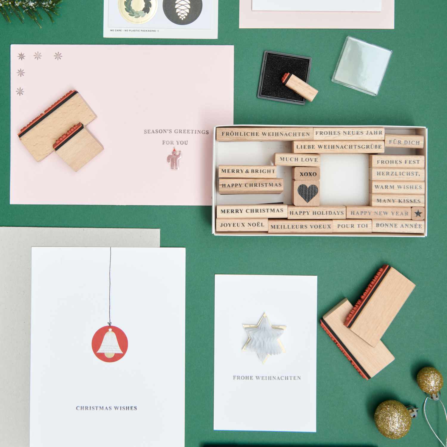 Paper Poetry XL Stempelset Merry Christmas serif, 27-teilig, von Rico Design auf einem Tisch mit Weihnachtskarten und Stempeln arrangiert.