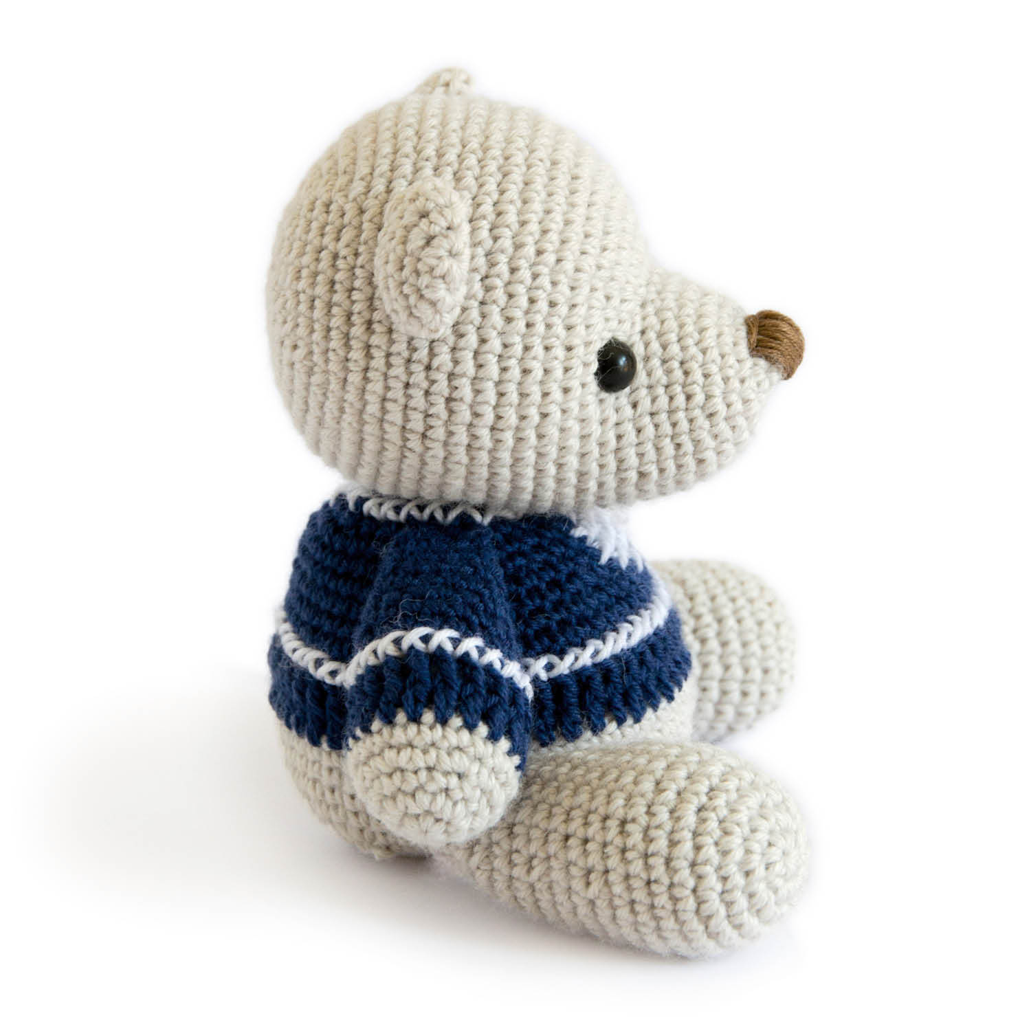 Häkelanleitung Teddybär - Ein gehäkelter Teddybär in cremefarbenem Garn mit blauem Pullover.