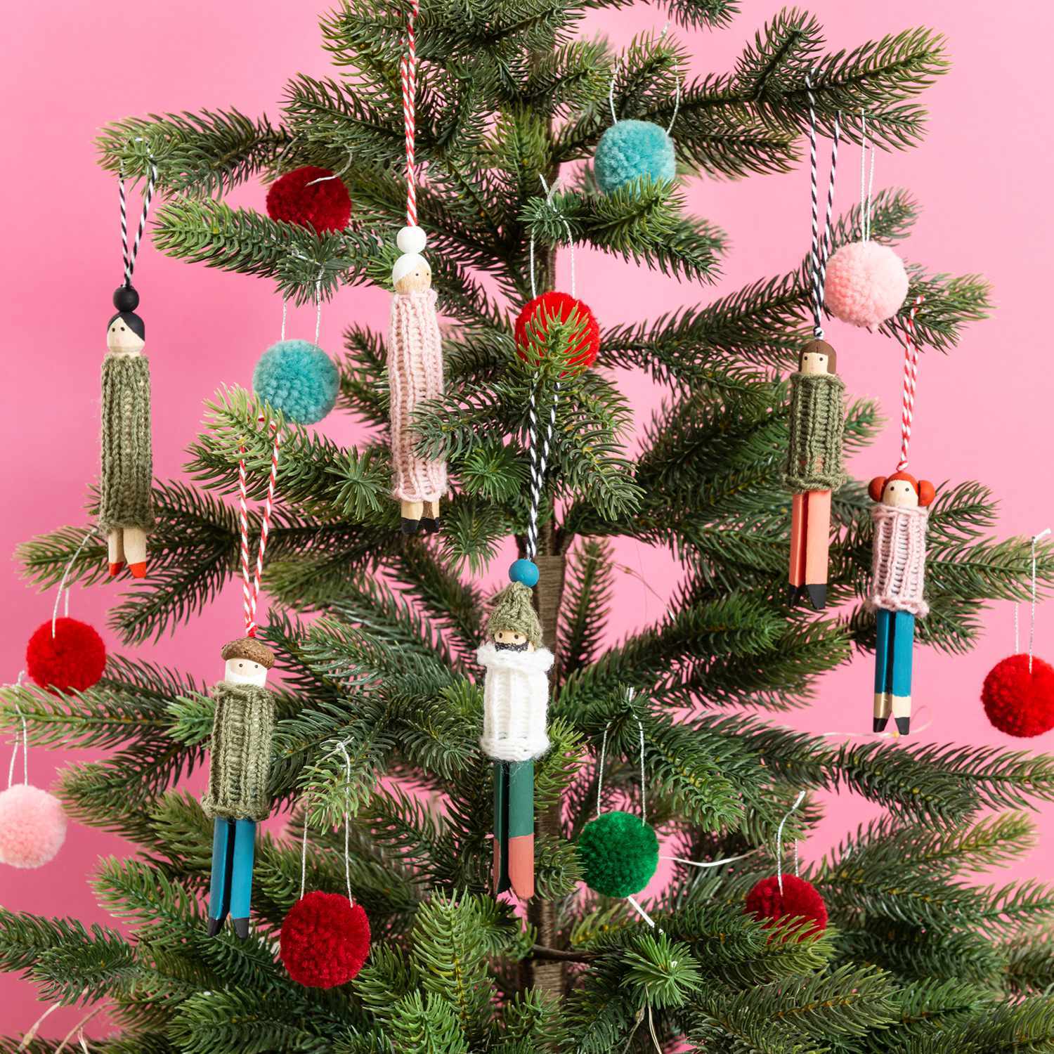 Bastelanleitung Baumschmuck aus Wäscheklammern: Kreativer Christbaumschmuck aus bunten Wäscheklammern und Pompons an einem Tannenbaum.