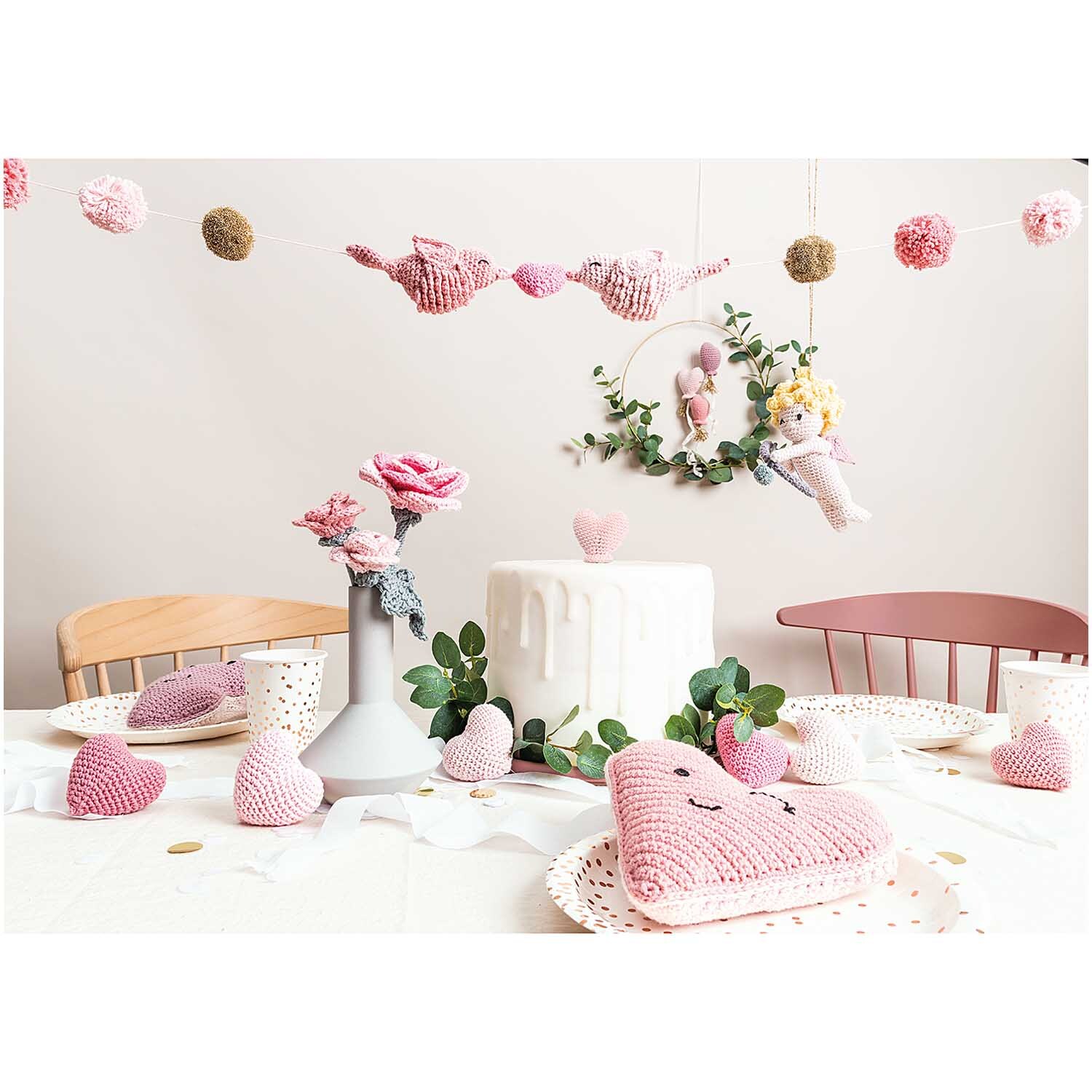 Creative Ricorumi dk: Ein festlich dekorierter Tisch mit rosa Häkeldekorationen und Blumen.