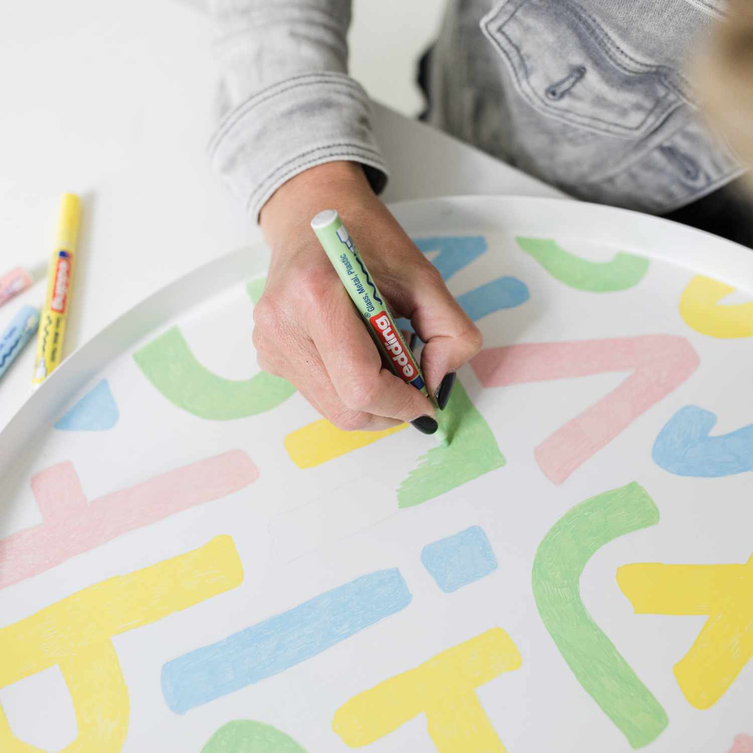 751 Glanzmarker in Pastellfarben auf einem weißen Tablett, das mit bunten Buchstaben bemalt wird. Ideal für kreative Projekte.