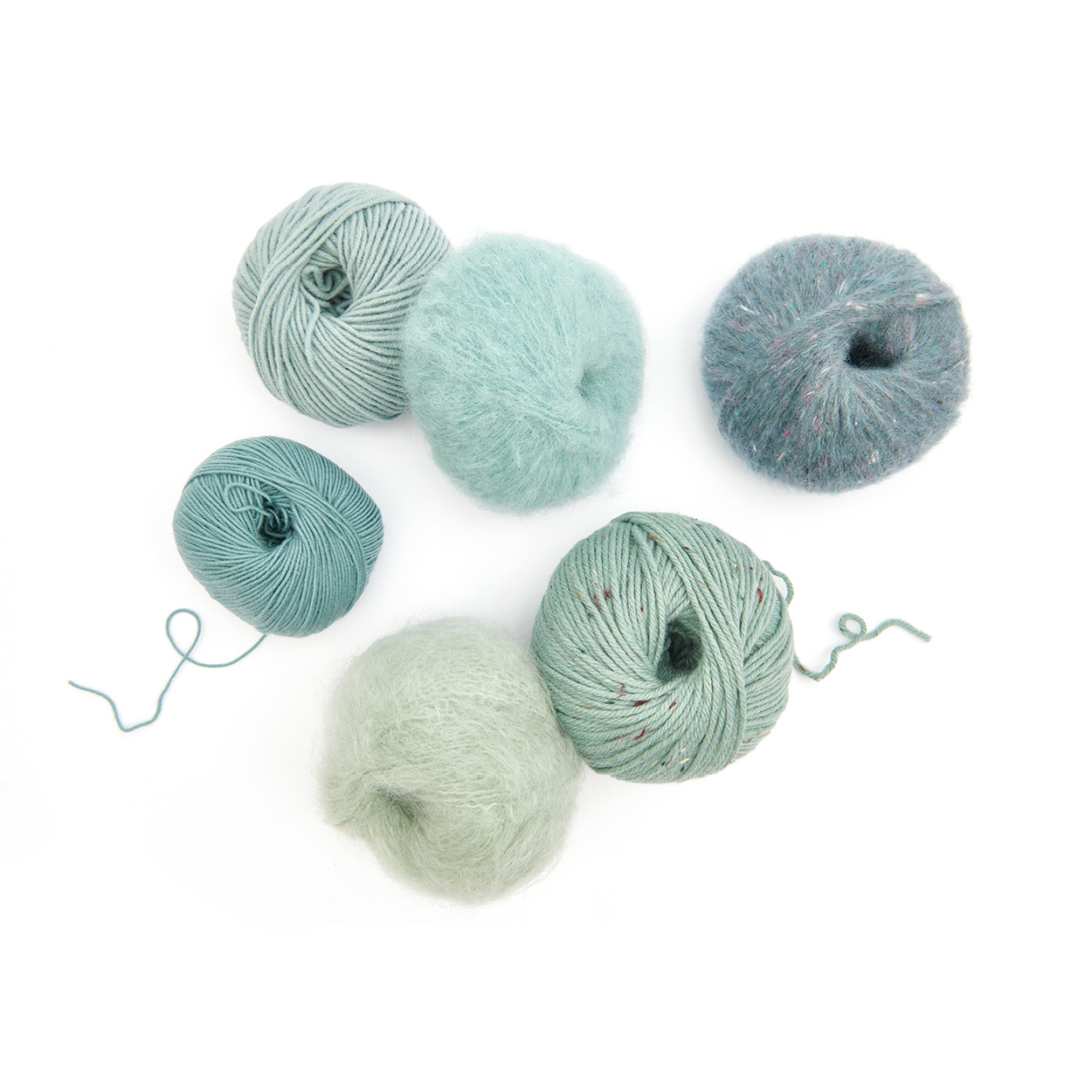 Verschiedene Wollknäuel in blau und Mint-Farben. Flatlay von Produkten.