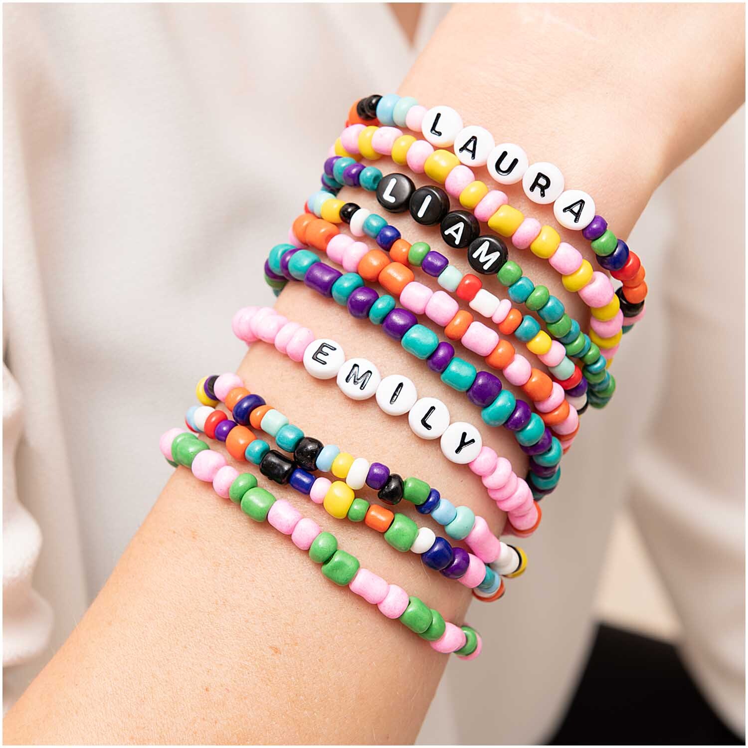 Perlen Buchstaben-Mix rund ca. 165 Stück: Bunte Armbänder mit Buchstabenperlen an einem Arm.