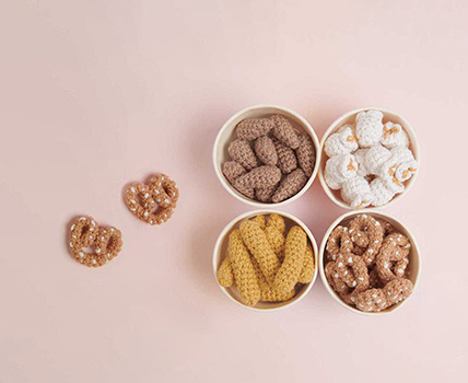 Gehäkelte Mandeln, Popcorn, Erdnüsse und Brezel in Papierschälchen. Häkelfiguren aus Ricorumi Snacks.