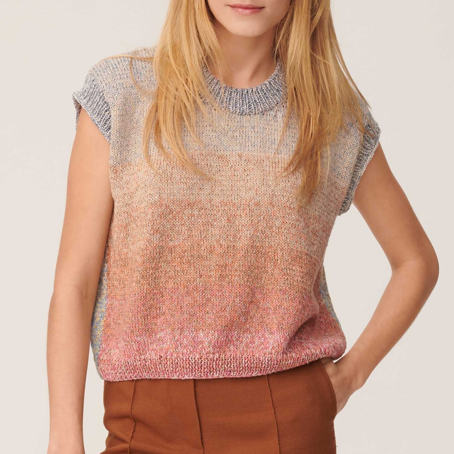 Strickanleitung Shirt aus Creative Cotton Dégradé Lucky 8: Frau trägt ein kurzärmeliges, mehrfarbiges Strickshirt in sanften Pastelltönen.