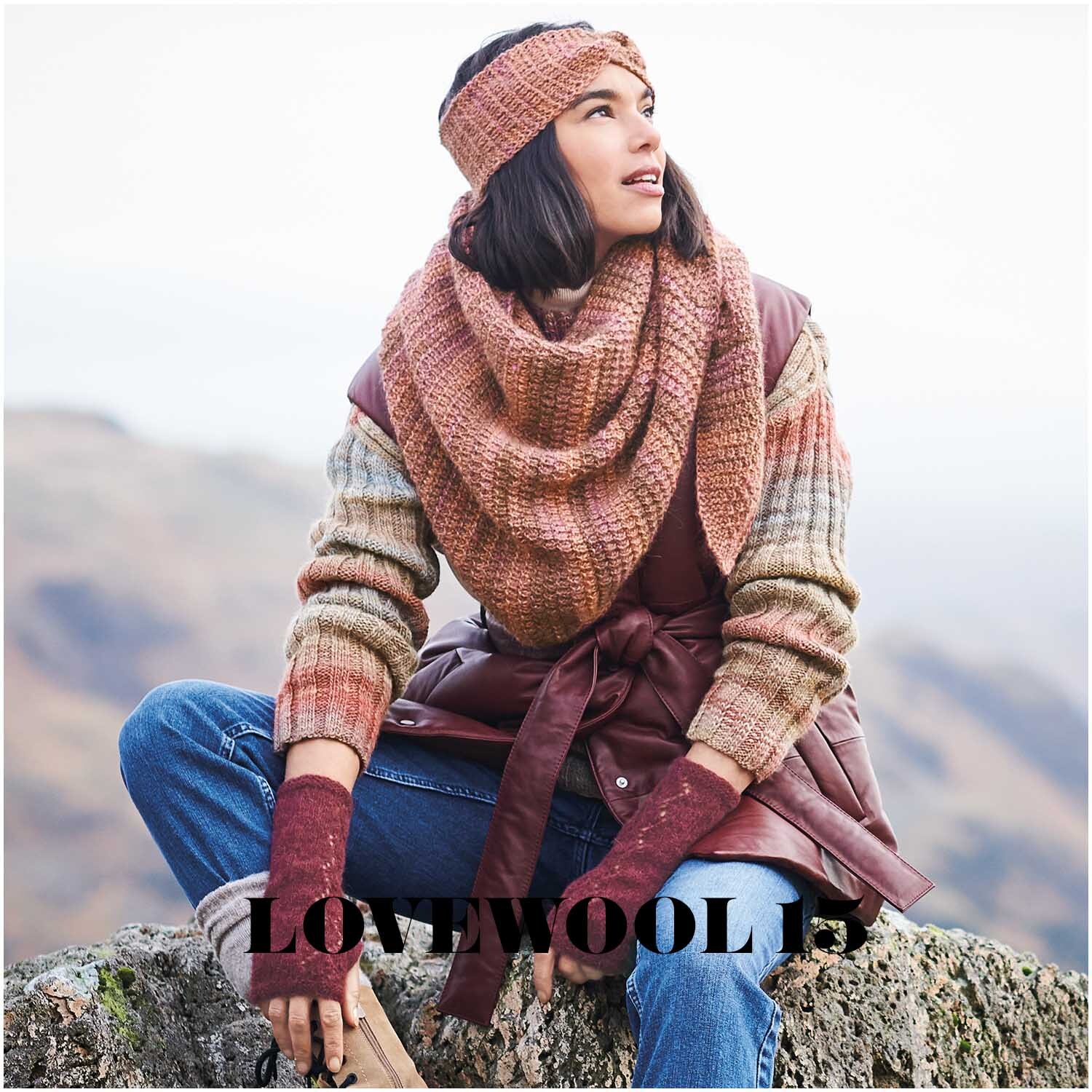 Creative Alpaca Melange aran: Frau in gestricktem Outfit mit Stirnband und Schal in Apricot, sitzt auf einem Felsen.