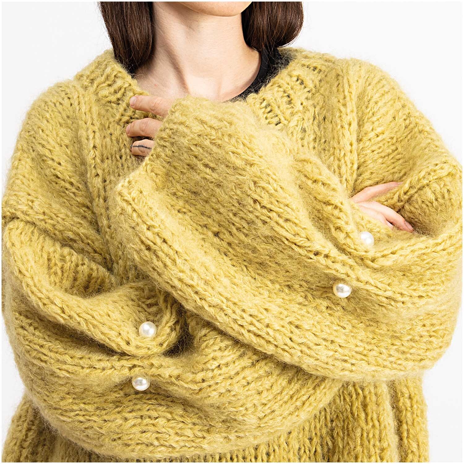 Zwei-Perlen-Pin 65mm 1 Stück: Frau in gelbem Strickpullover mit Perlweiß-Pins von Rico Design an den Ärmeln.