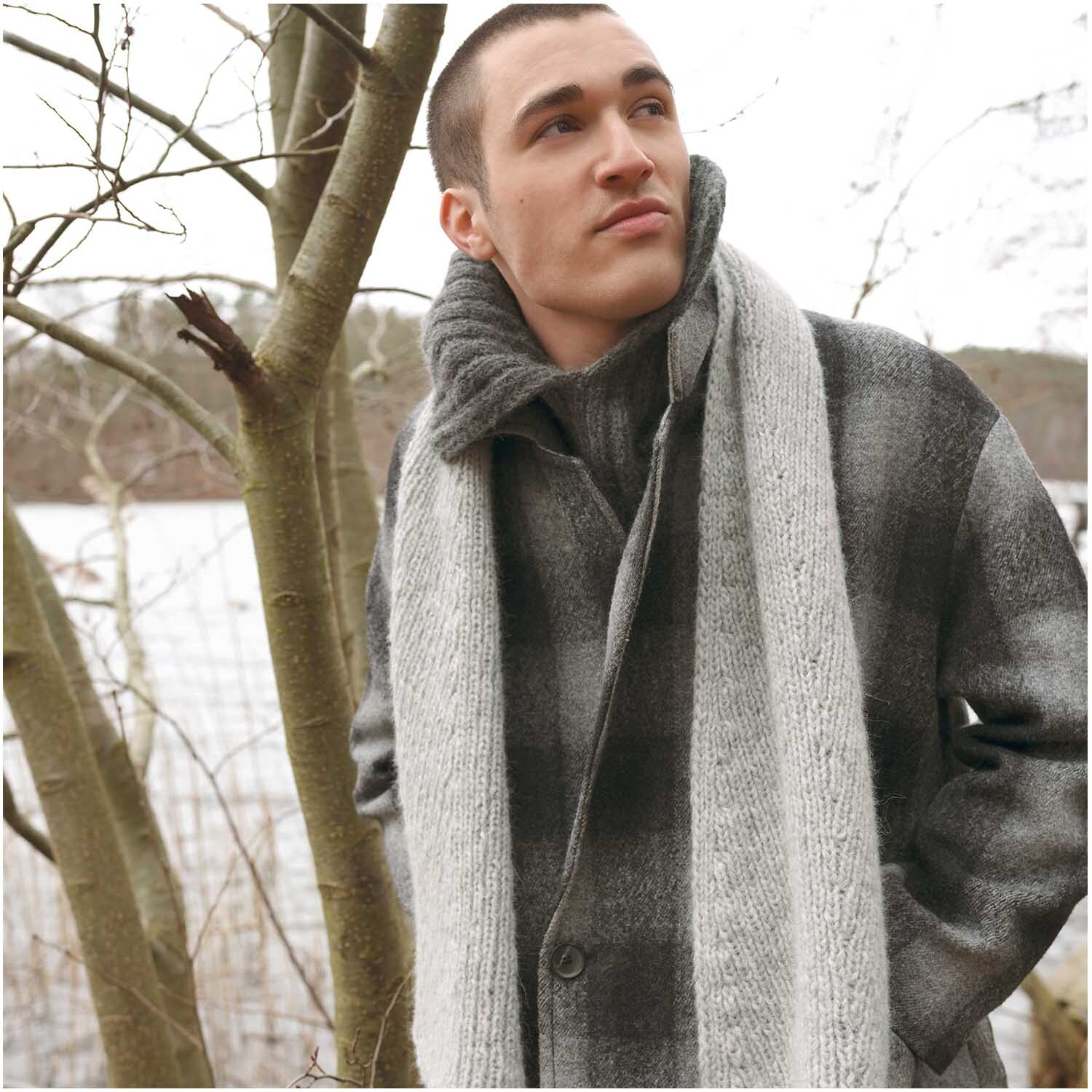 Strickset Kragen Modell 18: Mann in grauem Mantel mit passendem Schal, umgeben von winterlicher Natur. Ideal für stilvolle Wintermode.
