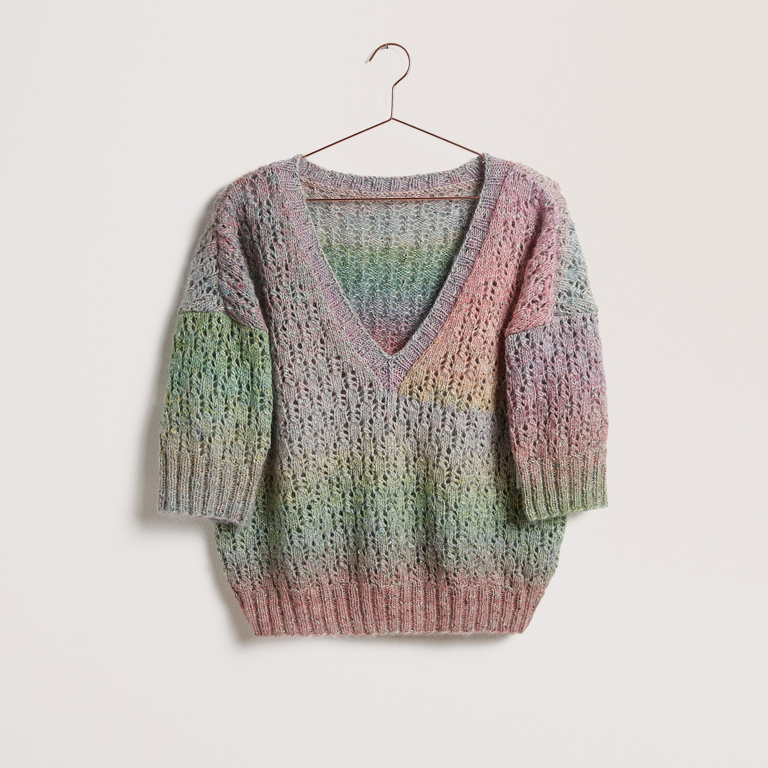 Bunter V-Ausschnitt Pullover auf grauem Hintergrund – zum Strickset
