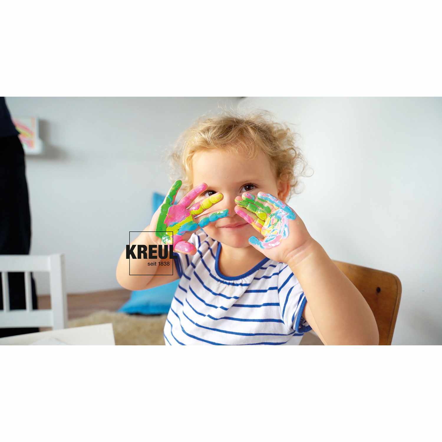 MUCKI Quietsch-Fingerfarbe: Ein Kind malt mit leuchtenden Neonfarben von KREUL auf den Händen.