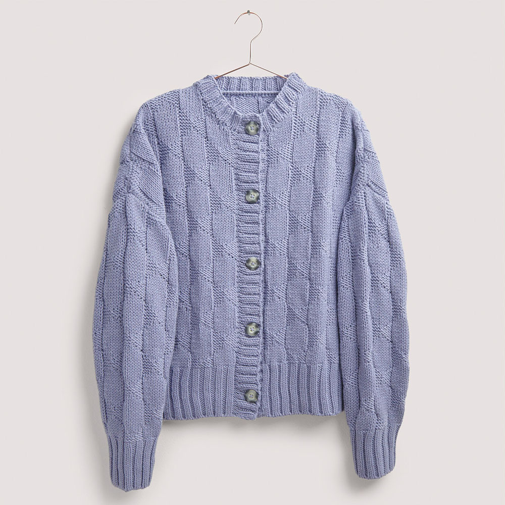 Lila Strickjacke auf grauem Hintergrund – zum Strickset