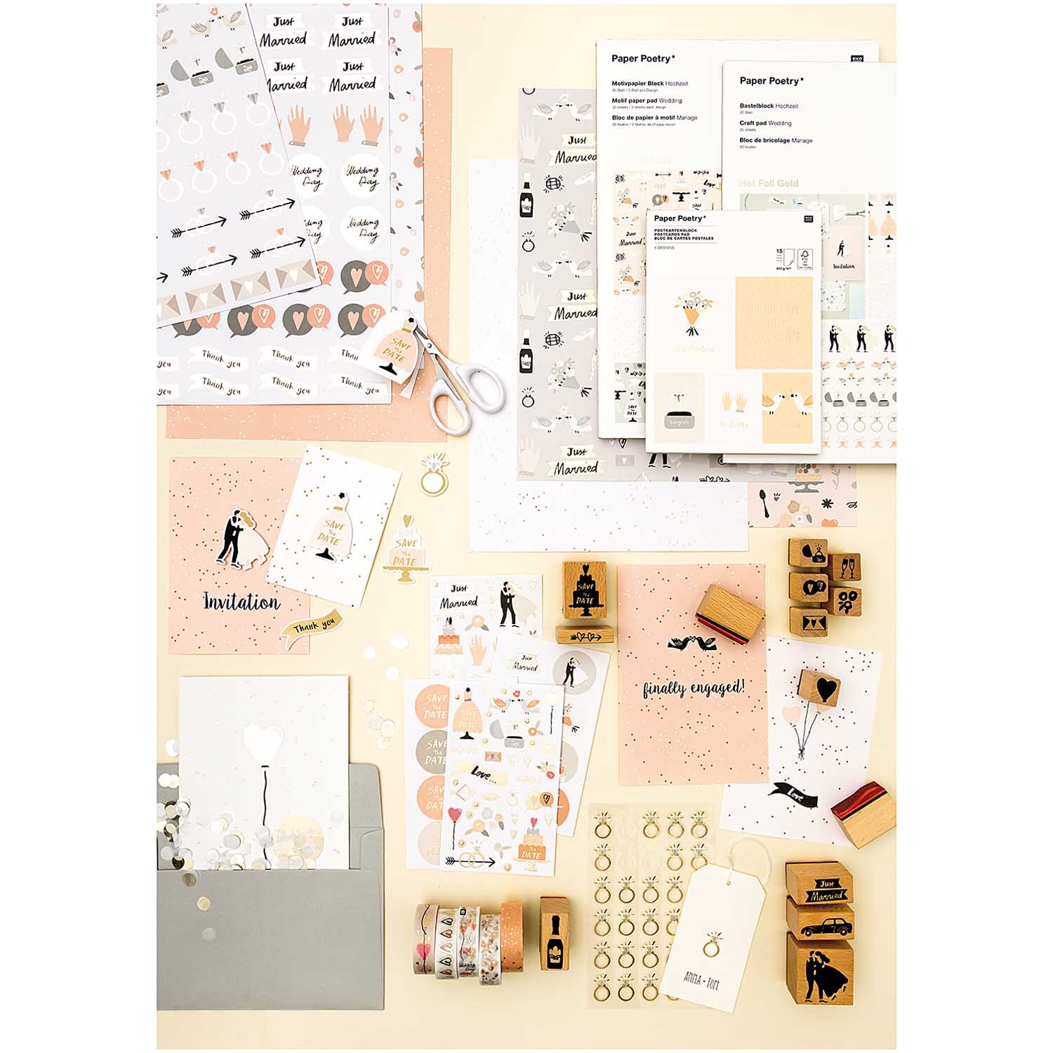Paper Poetry Gelsticker Ringe gold auf einem Tisch mit Bastelmaterialien und Einladungen. Ideal für kreative Projekte.