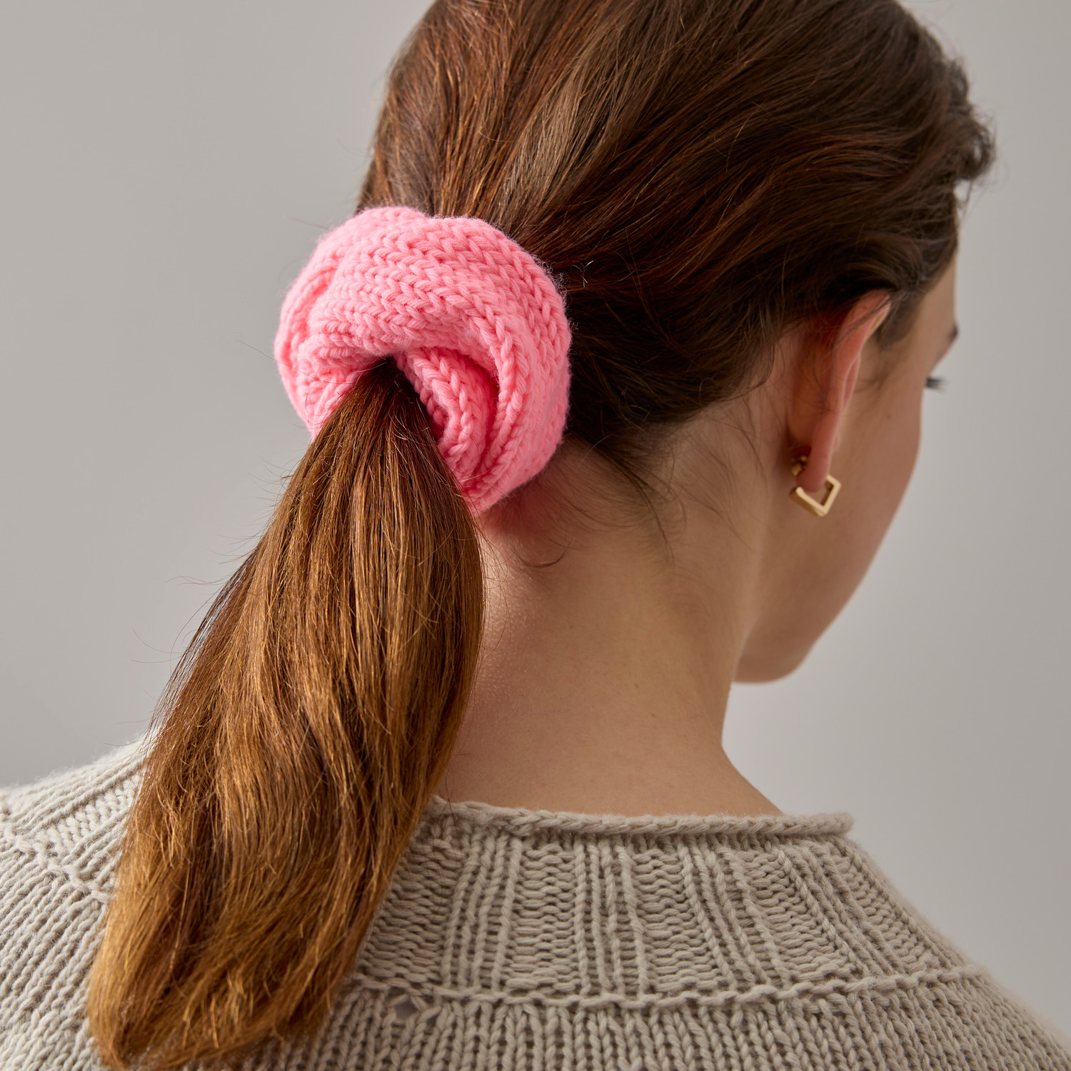 Strickset Scrunchie Modell 04b aus Vegan Cashmere in leuchtendem Pink, getragen im Haar.