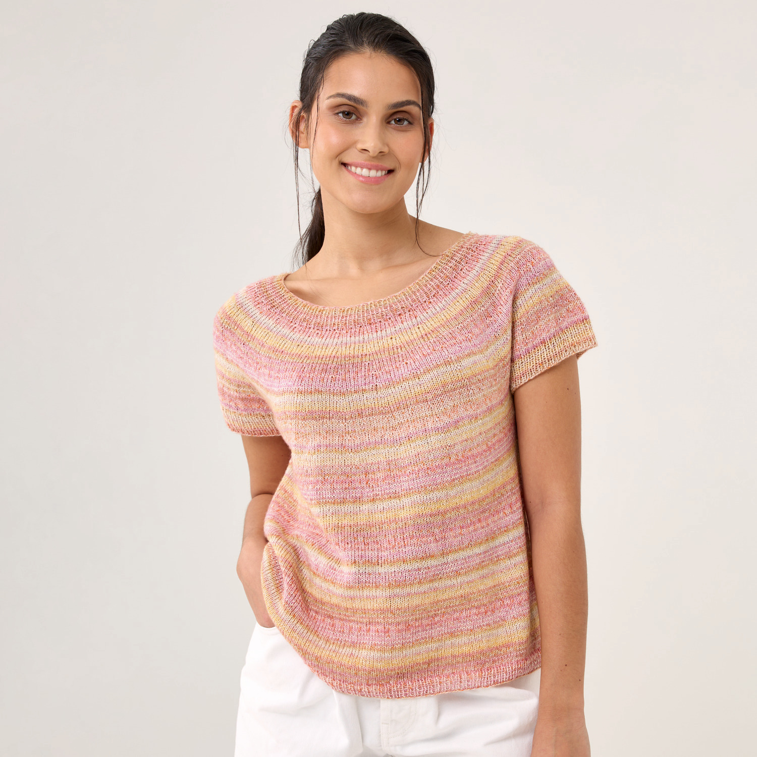 Strickset Shirt Modell 08: Frau trägt ein bunt gestreiftes, kurzärmeliges Strickshirt.
