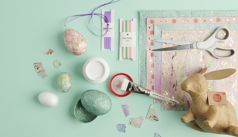 Anleitung Ostereier gestalten mit Paper Patch: Materialien wie Schere, Pinsel, Papier und Eier auf mintgrünem Hintergrund.