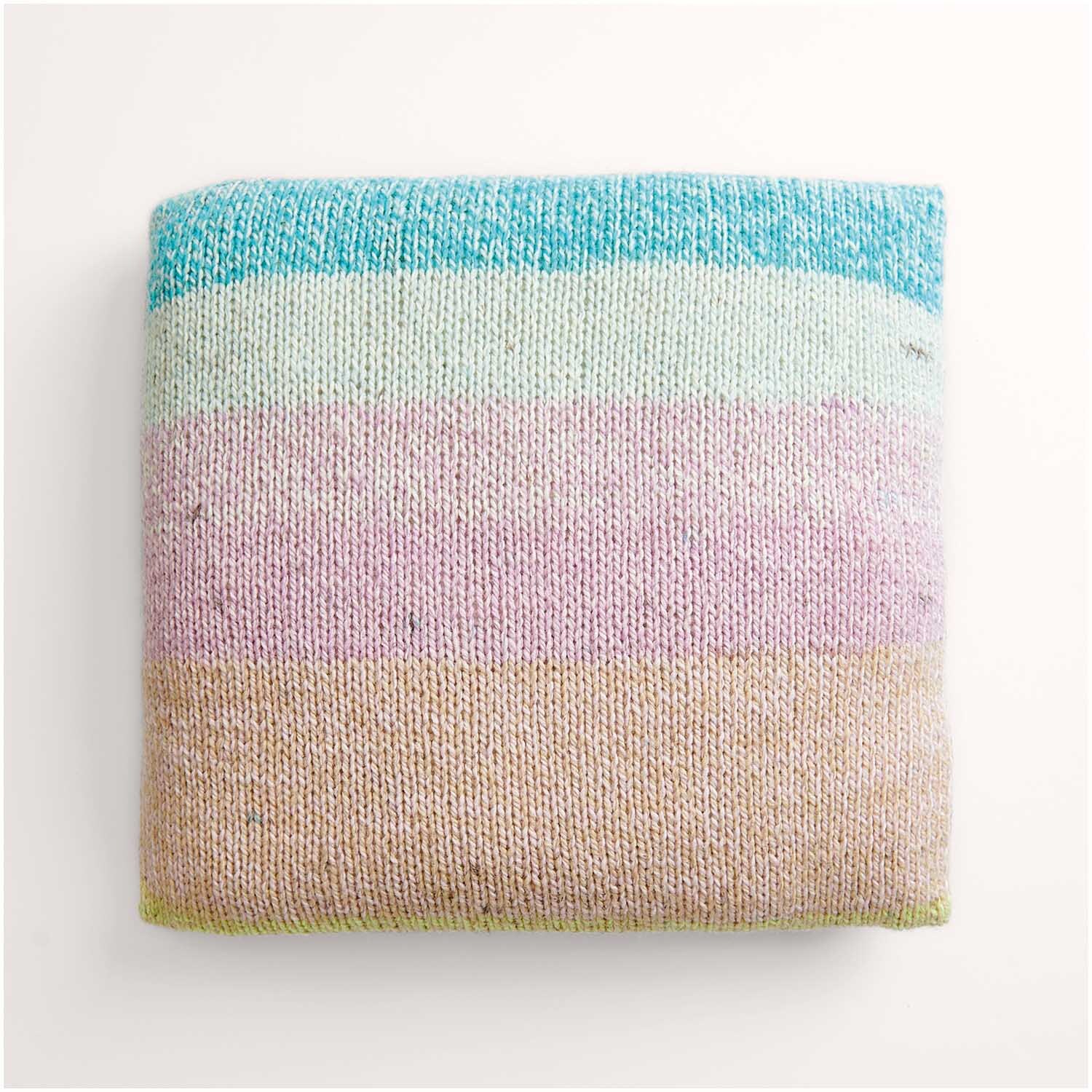 Strickset Kissen Modell 04: Ein gestricktes Kissen in Pastellfarben, gestreift in Blau, Rosa und Beige.